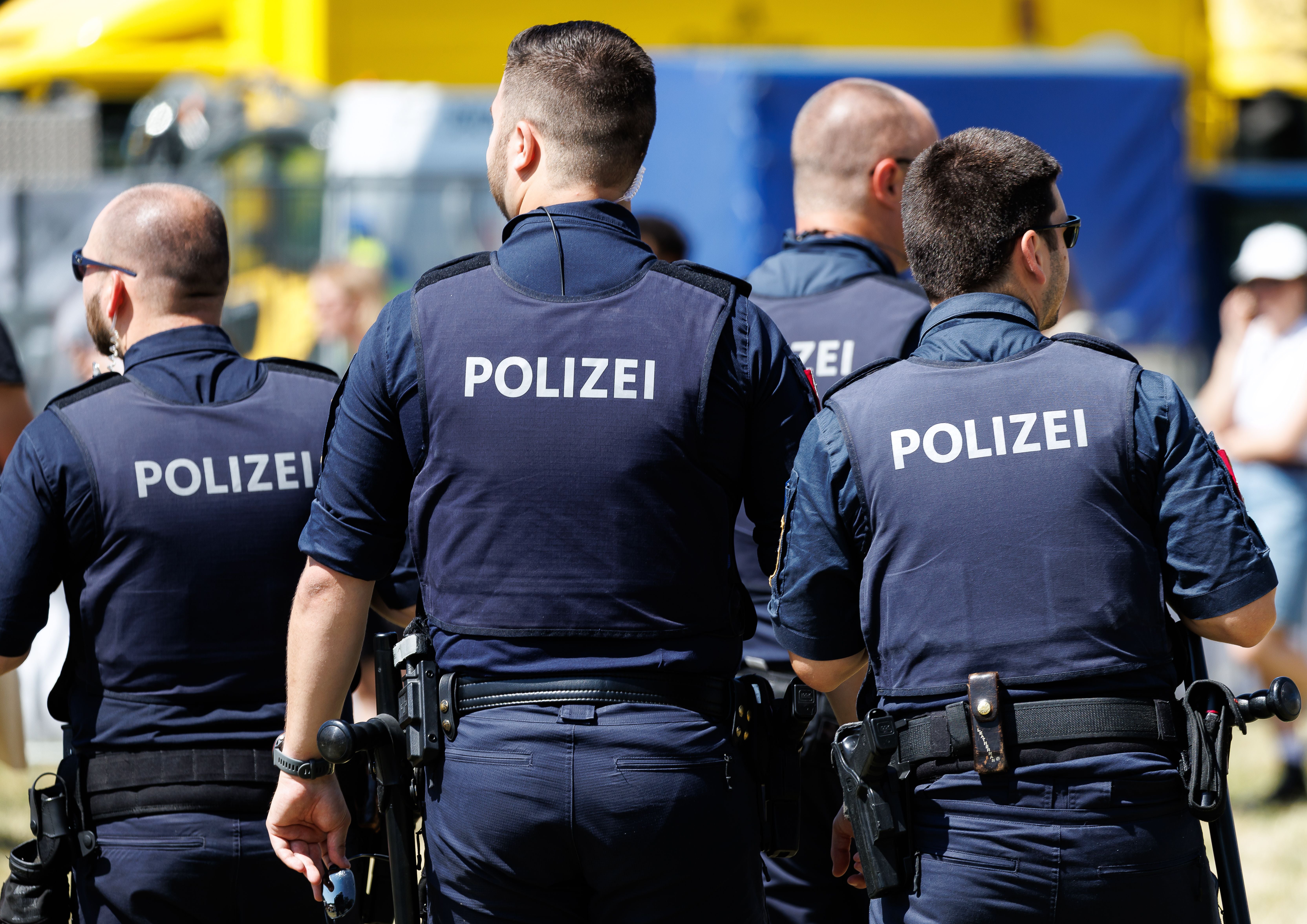 Vier Polizisten stehen in Uniform auf der Donauinsel während des Donauinselfests in Wien.
