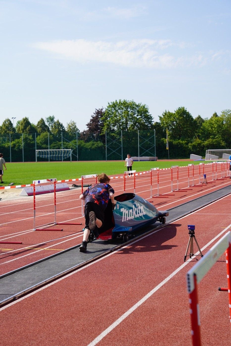 Person schiebt einen Bobsimulator auf einer Laufbahn im Olympiazentrum Niederösterreich.