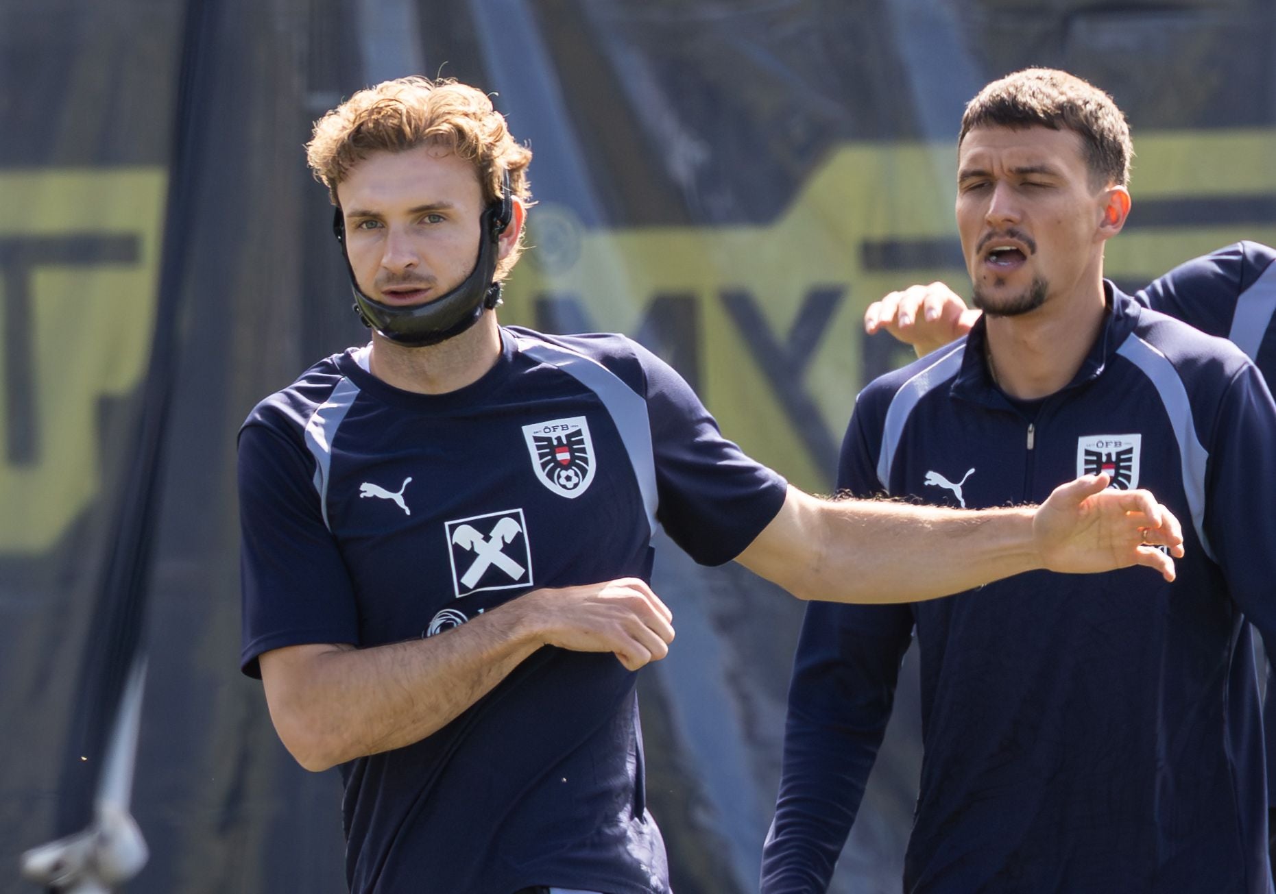 Zwei österreichische Fußballspieler im Trainingsoutfit beim Training im Freien.