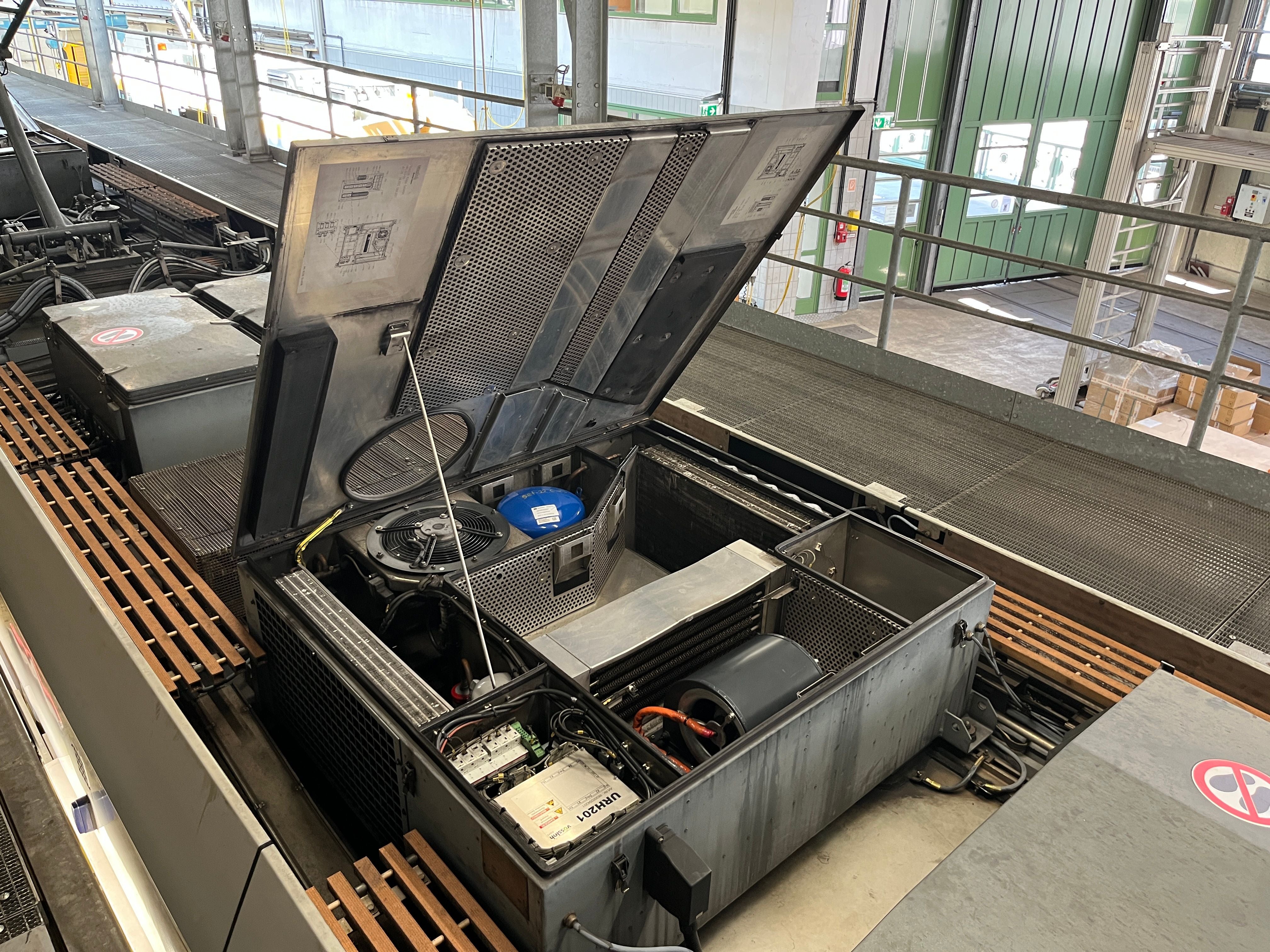 Geöffneter Technikraum eines Öffis mit sichtbaren elektronischen Komponenten und Kabeln.