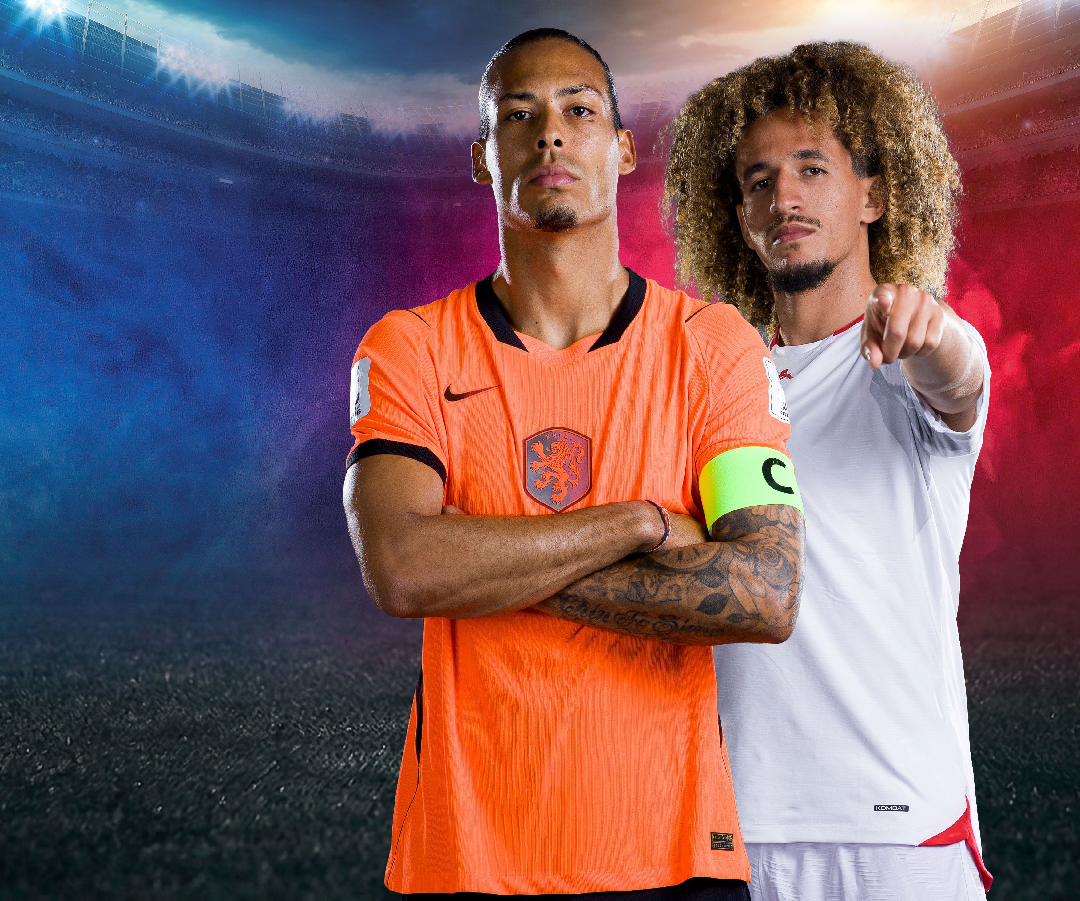 Zwei Fußballspieler, einer im orangen Niederlande-Trikot, einer im weißen Tunesien-Trikot.