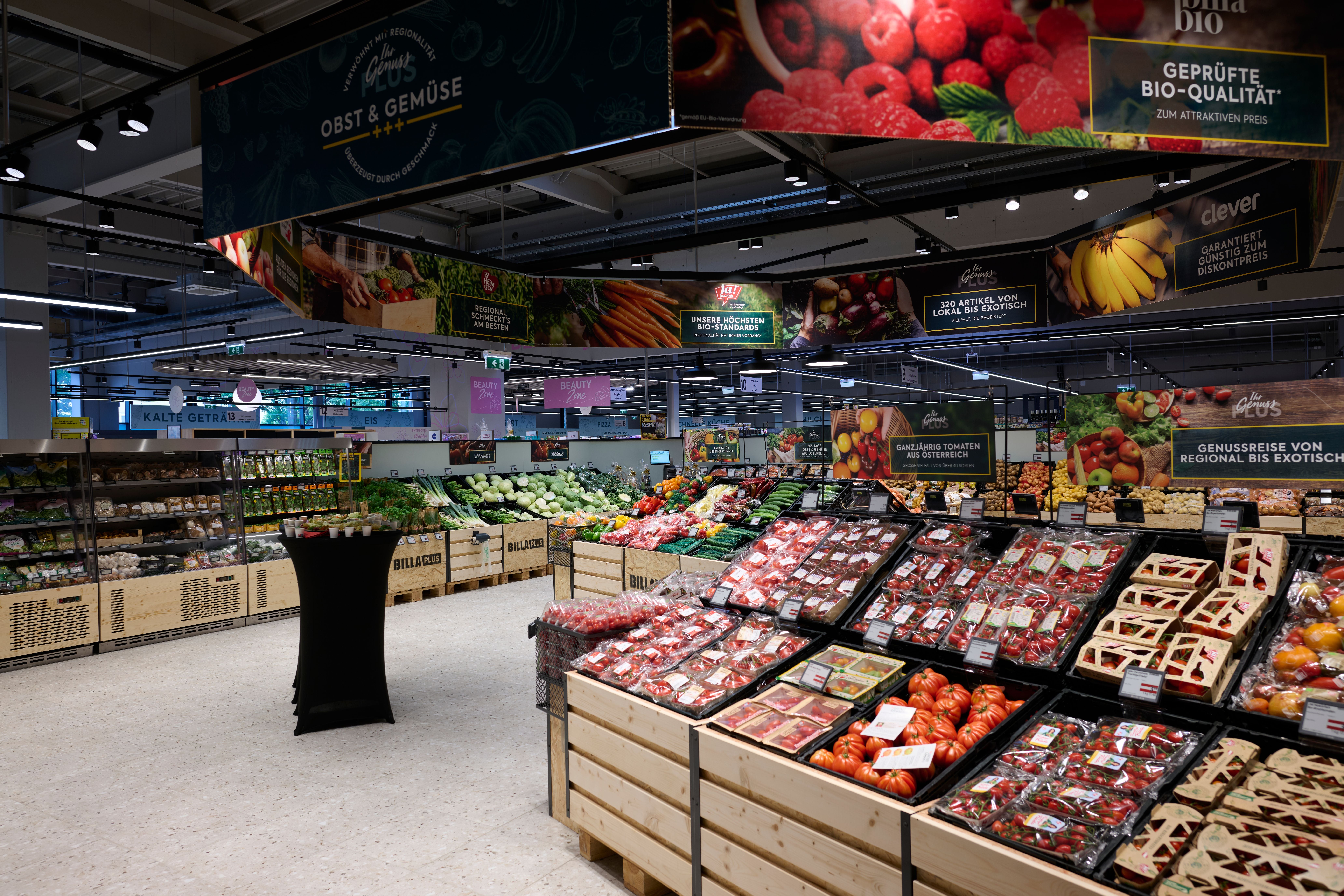 Obstabteilung in einem Billa Plus Supermarkt mit frischem Obst und Gemüse in Holzkisten.