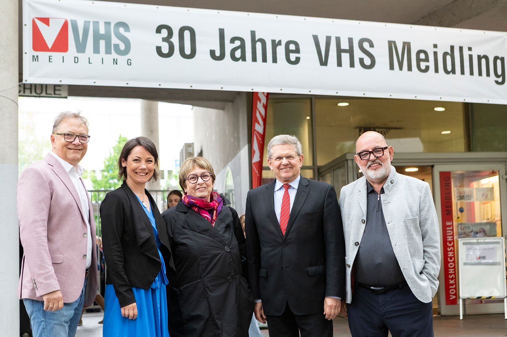 Fünf Personen stehen vor einem Banner mit der Aufschrift „30 Jahre VHS Meidling“.