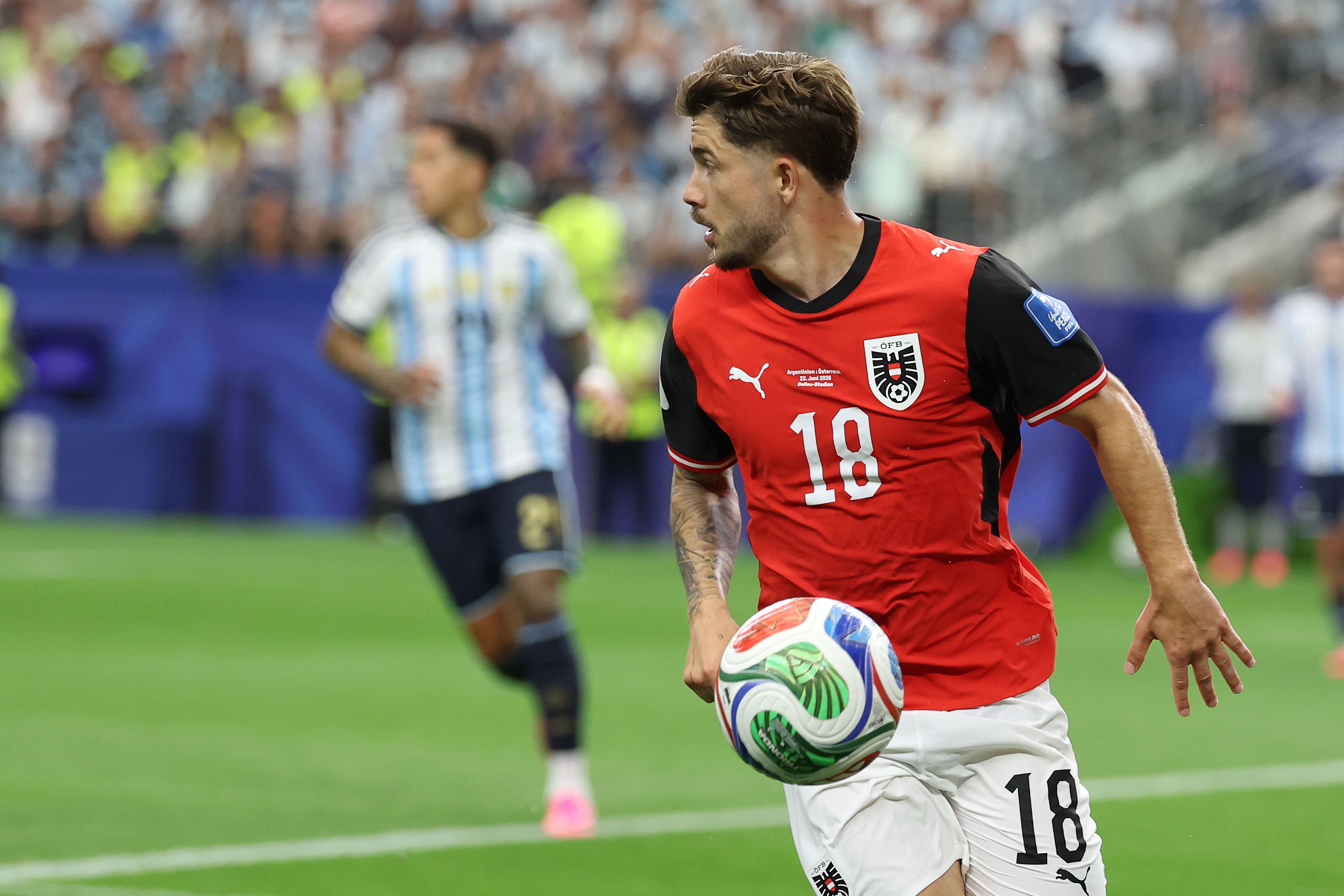 Ein österreichischer Fußballspieler im roten Trikot spielt während eines WM-Spiels gegen Argentinien.