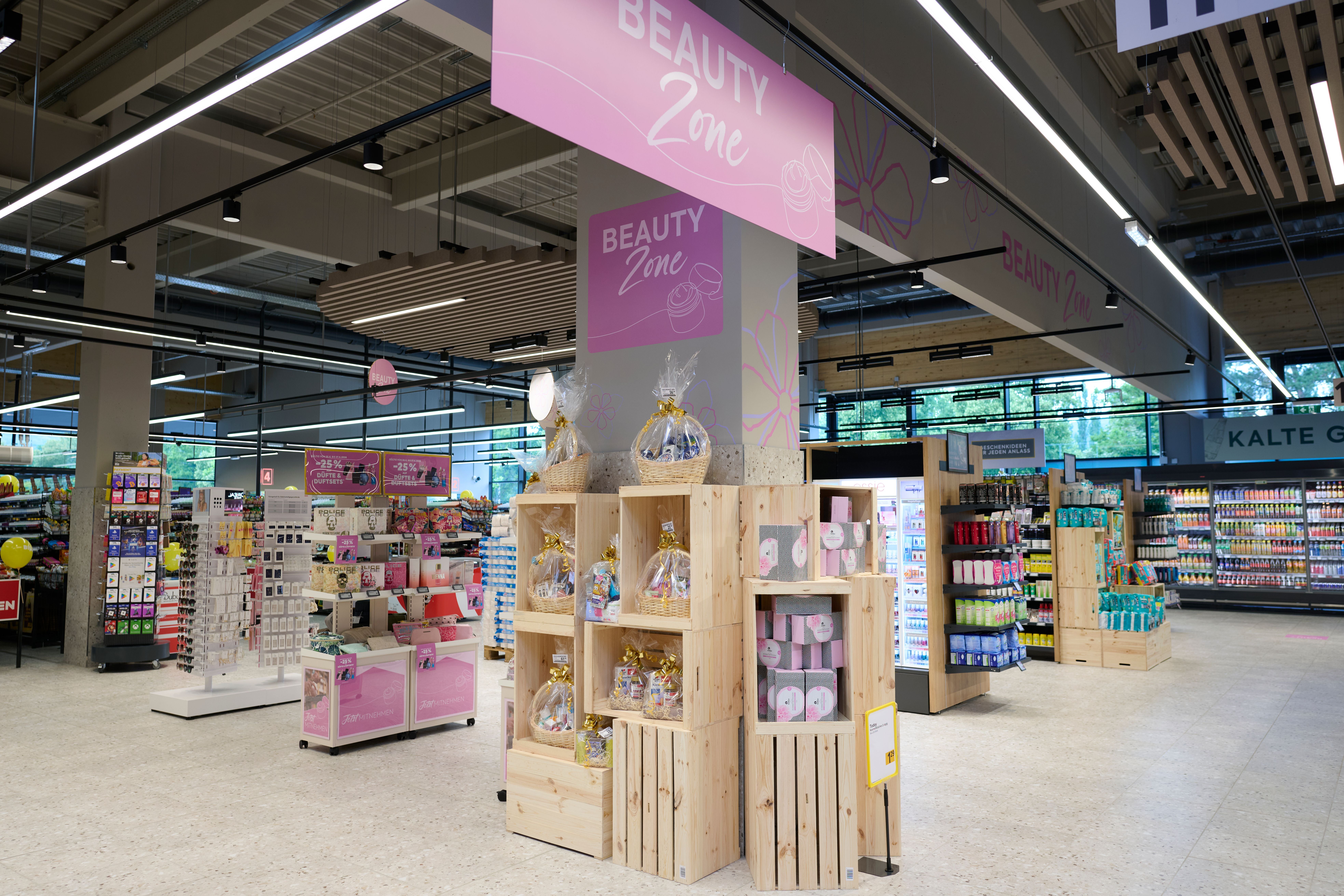 Kosmetikabteilung im Billa Plus Supermarkt mit Regalen voller Beauty-Produkte und Geschenksets.
