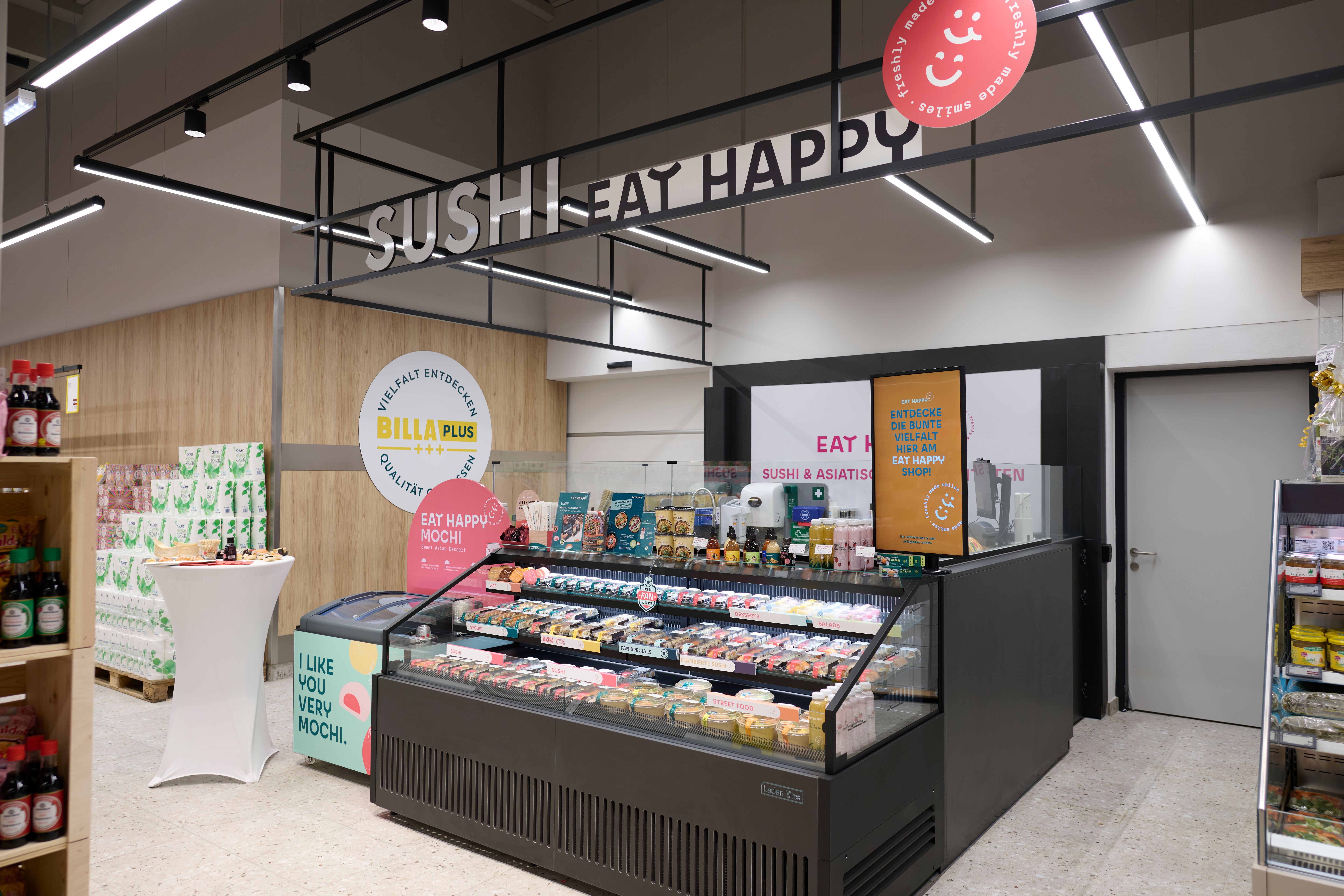 Sushitheke bei Billa Plus mit Auswahl an Sushi, asiatischen Snacks und Mochi im Kühlregal.