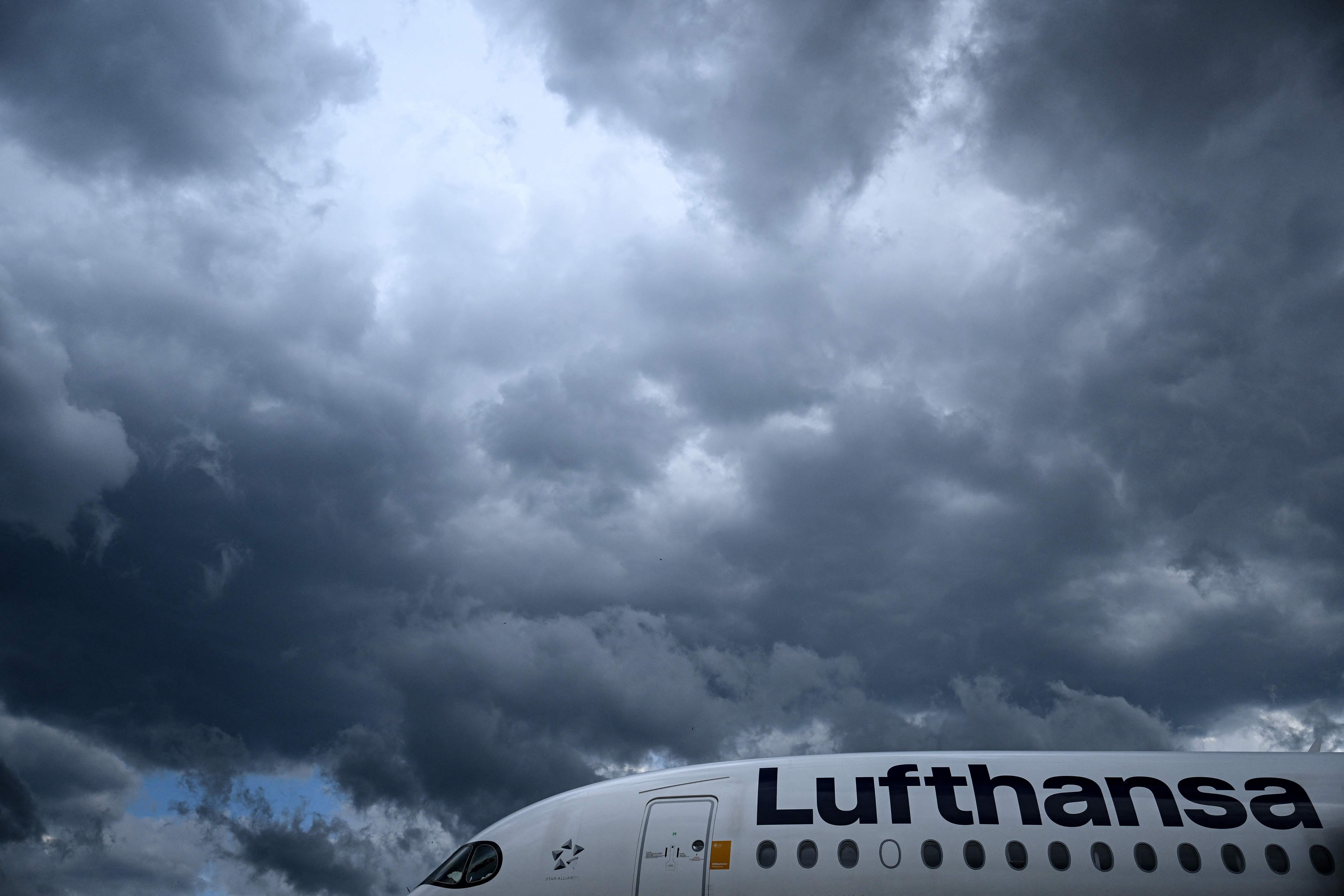 Ein Lufthansa-Flugzeug unter dunklen, bewölkten Himmel am Flughafen Frankfurt.
