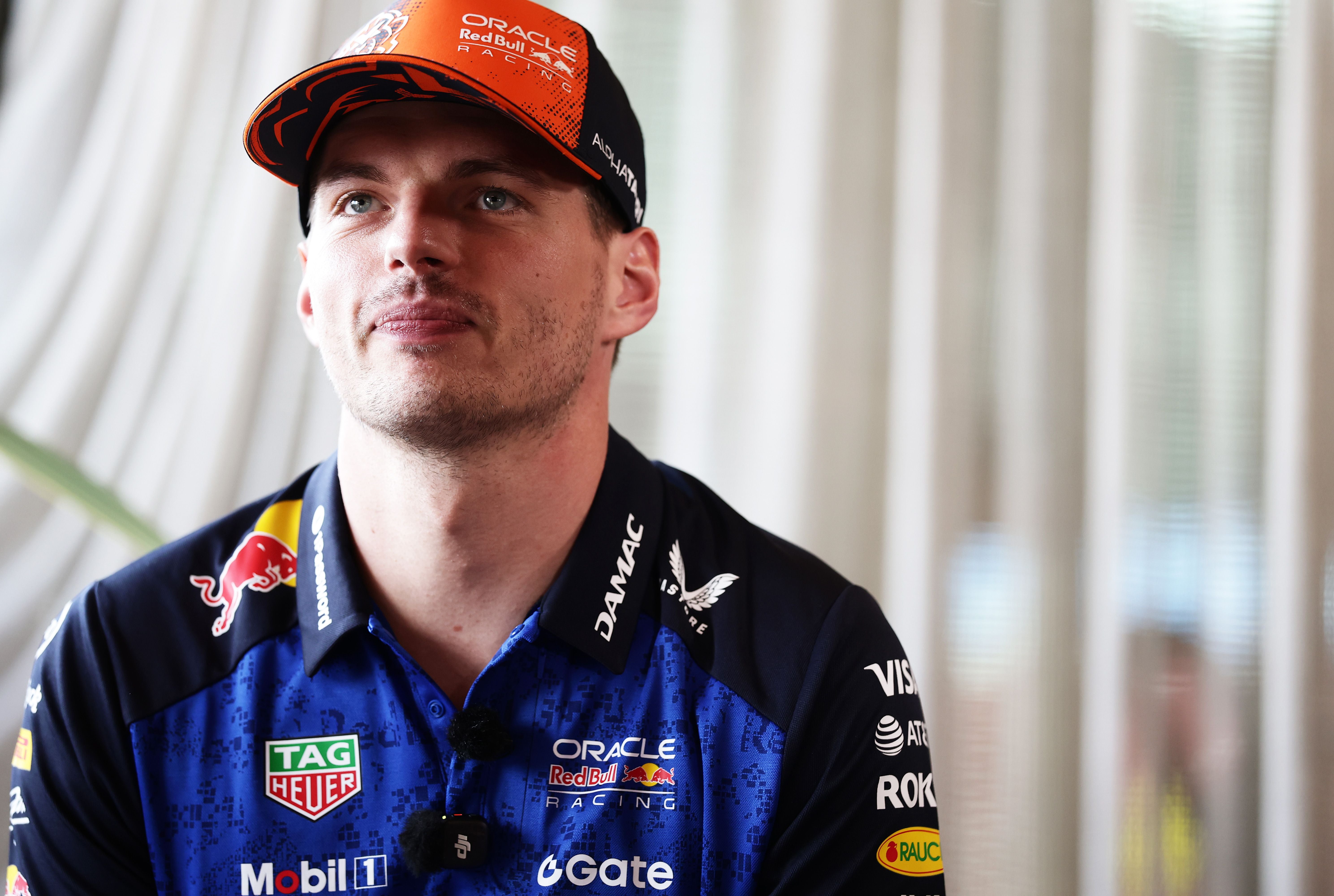 Eine Person im Red-Bull-Racing-Shirt und -Cap sitzt vor hellem Hintergrund.