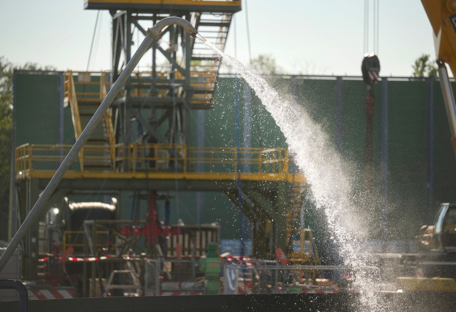 Wasserstrahl spritzt aus einem Rohr auf einer Tiefengeothermie-Anlage in Wien, Aspern.