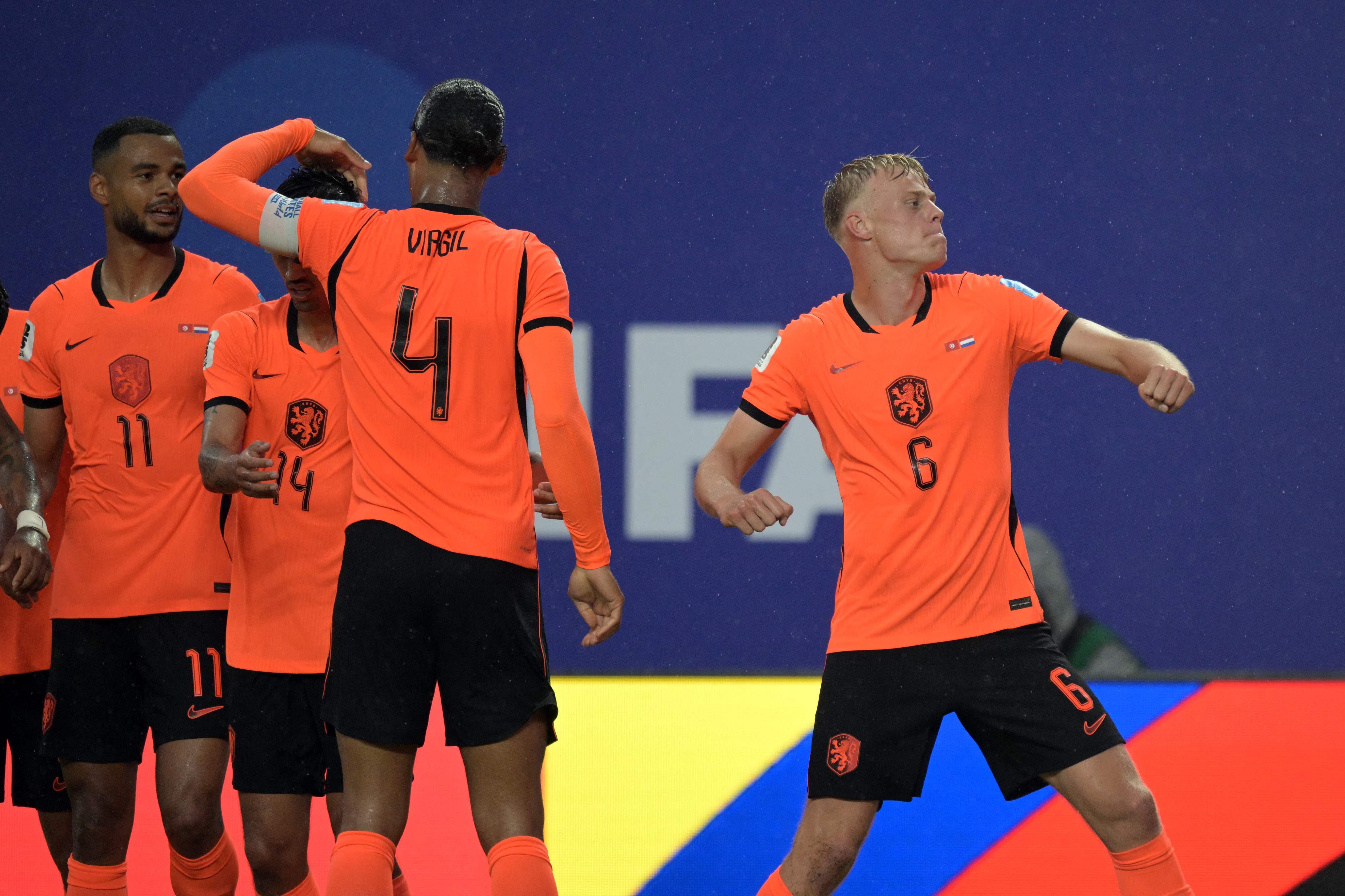 Niederländische Fußballspieler jubeln nach einem Tor im Stadion bei einem WM-Spiel.