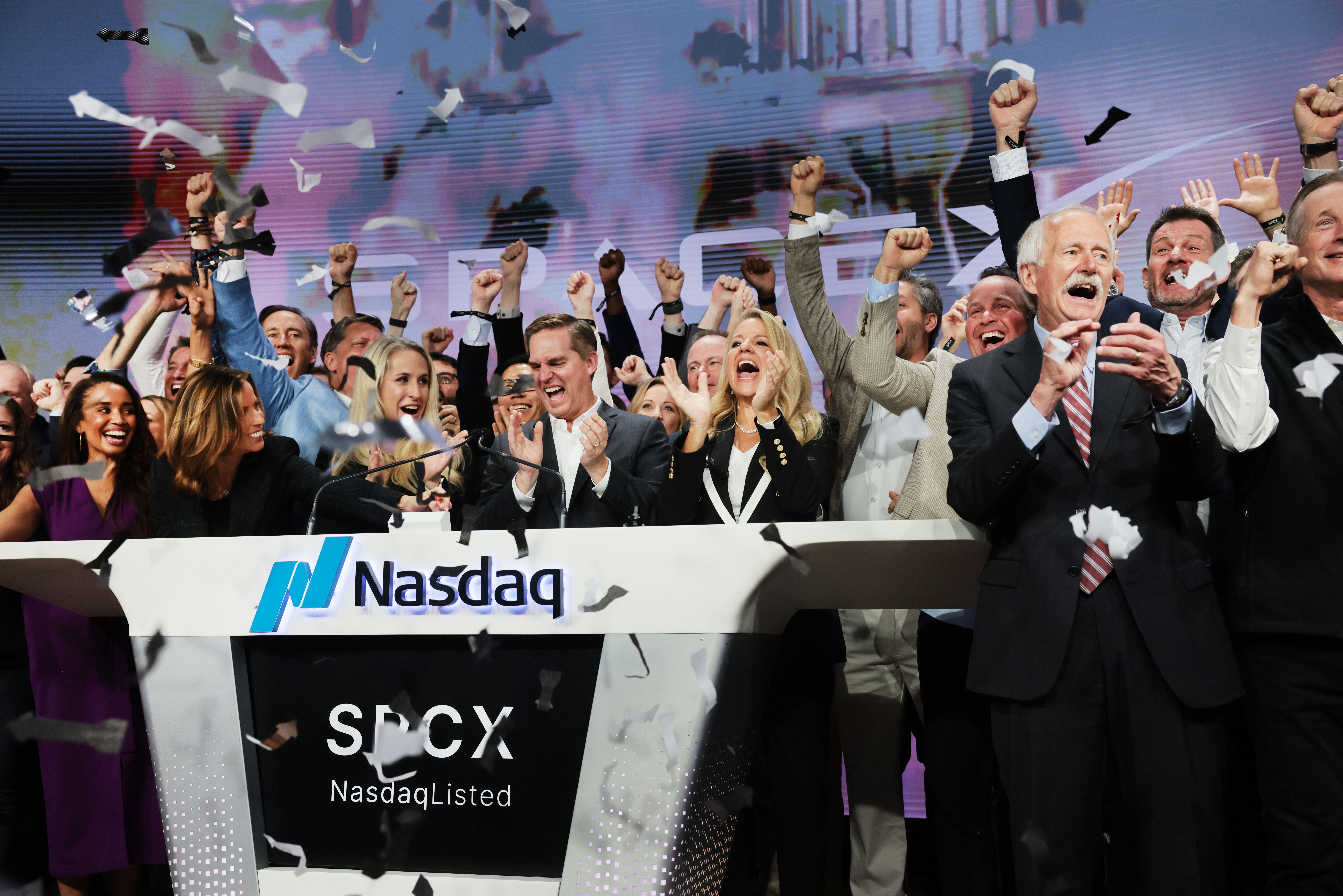 Menschen jubeln am Nasdaq-Pult, Konfetti fliegt, bei einer Feierstunde zur SpaceX-Börsennotierung.