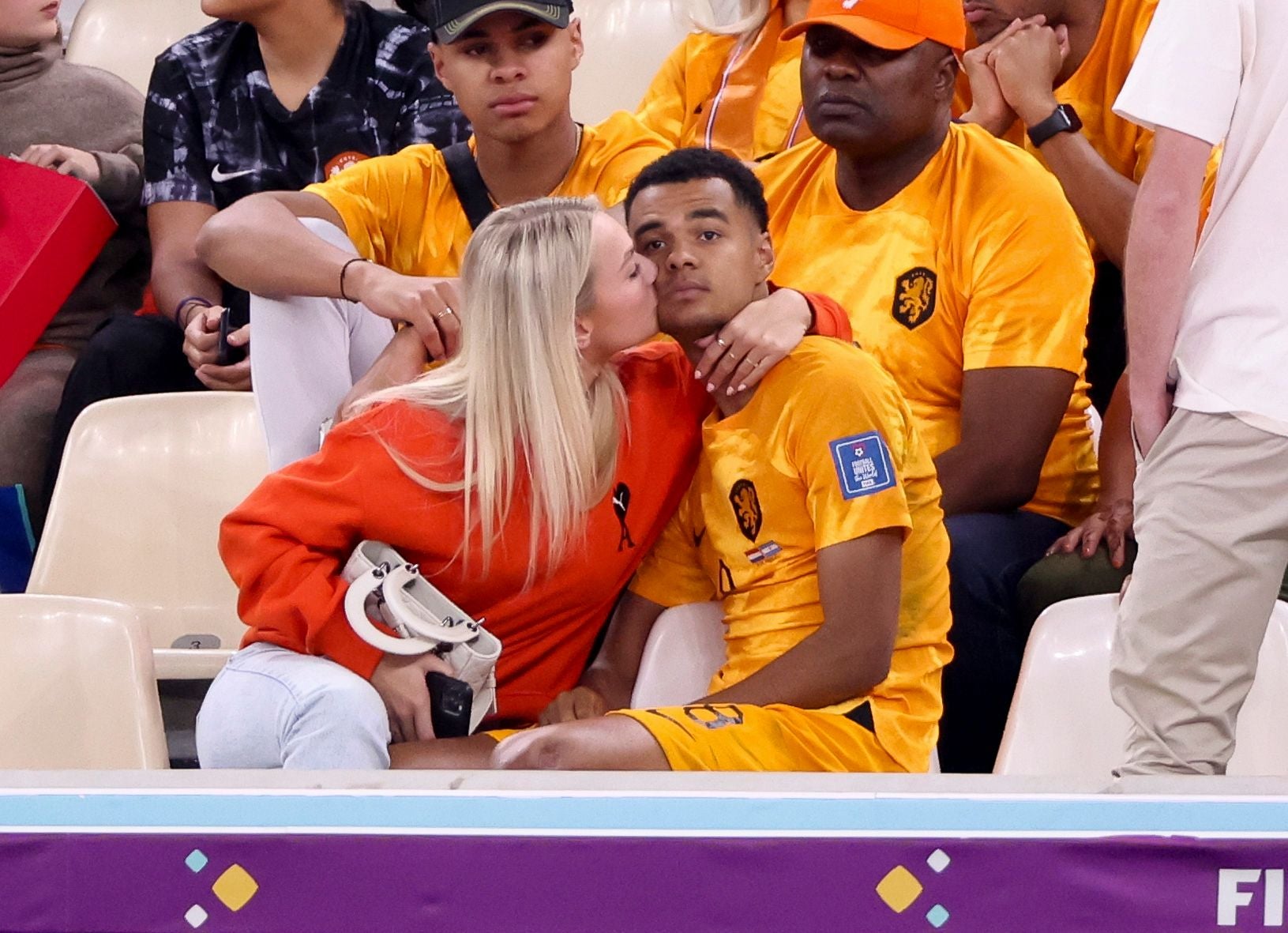Eine Frau küsst einen niederländischen Fußballspieler im Stadion auf die Wange.