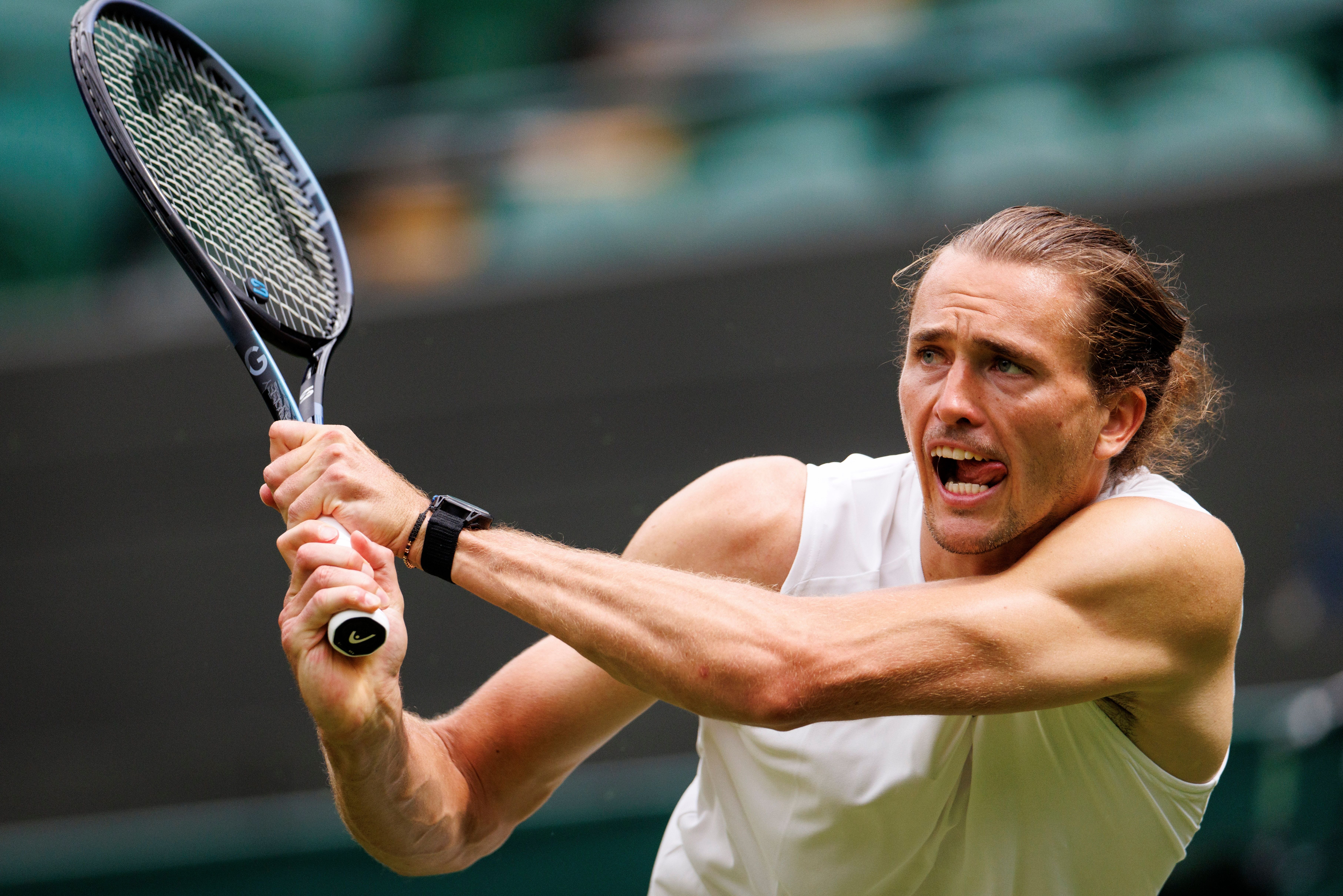 Ein Tennisspieler schlägt mit einem Schläger während eines Trainings auf dem Platz auf.
