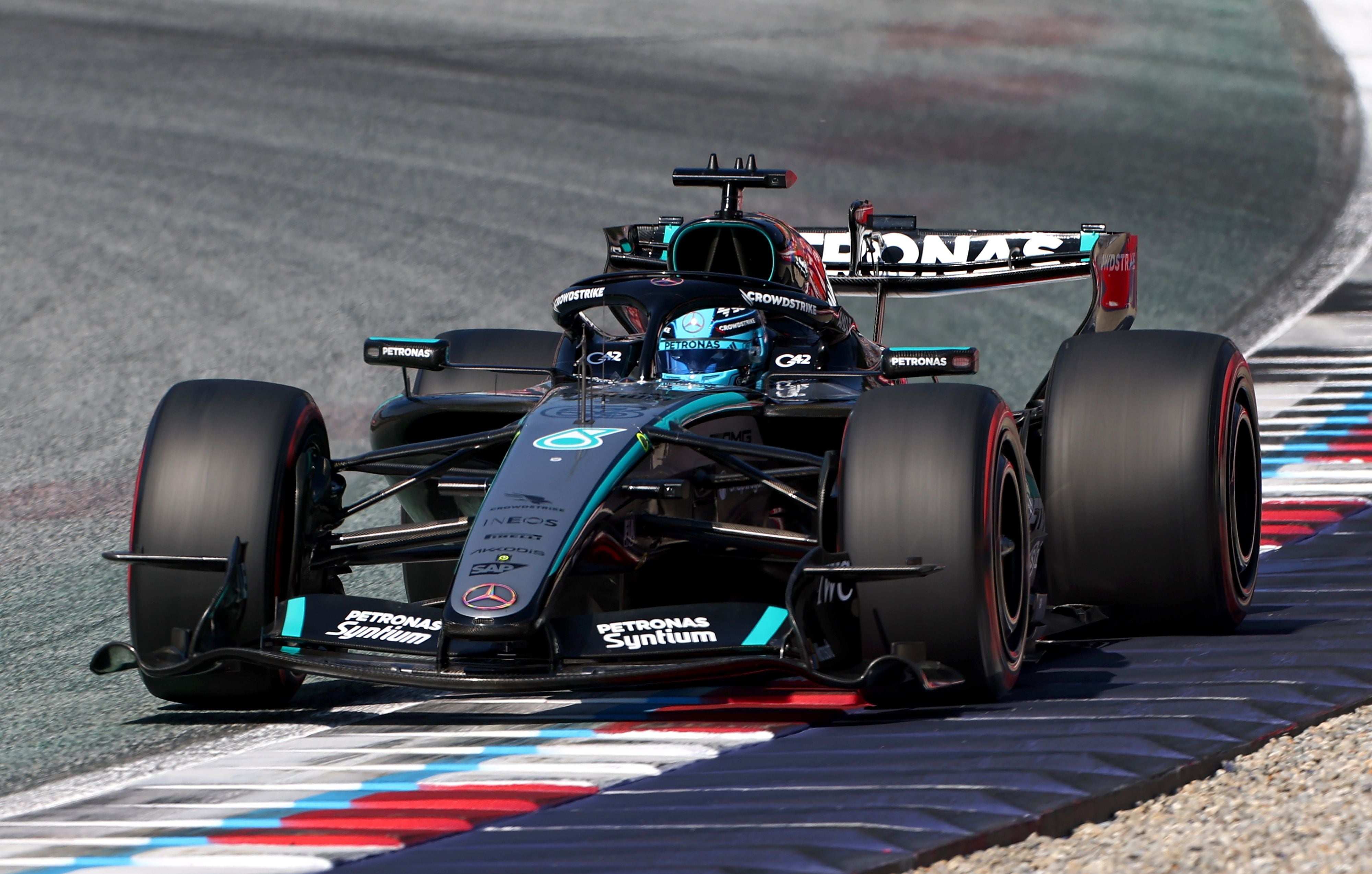 Ein schwarzer Mercedes-Formel-1-Wagen fährt über die Randsteine einer Rennstrecke.