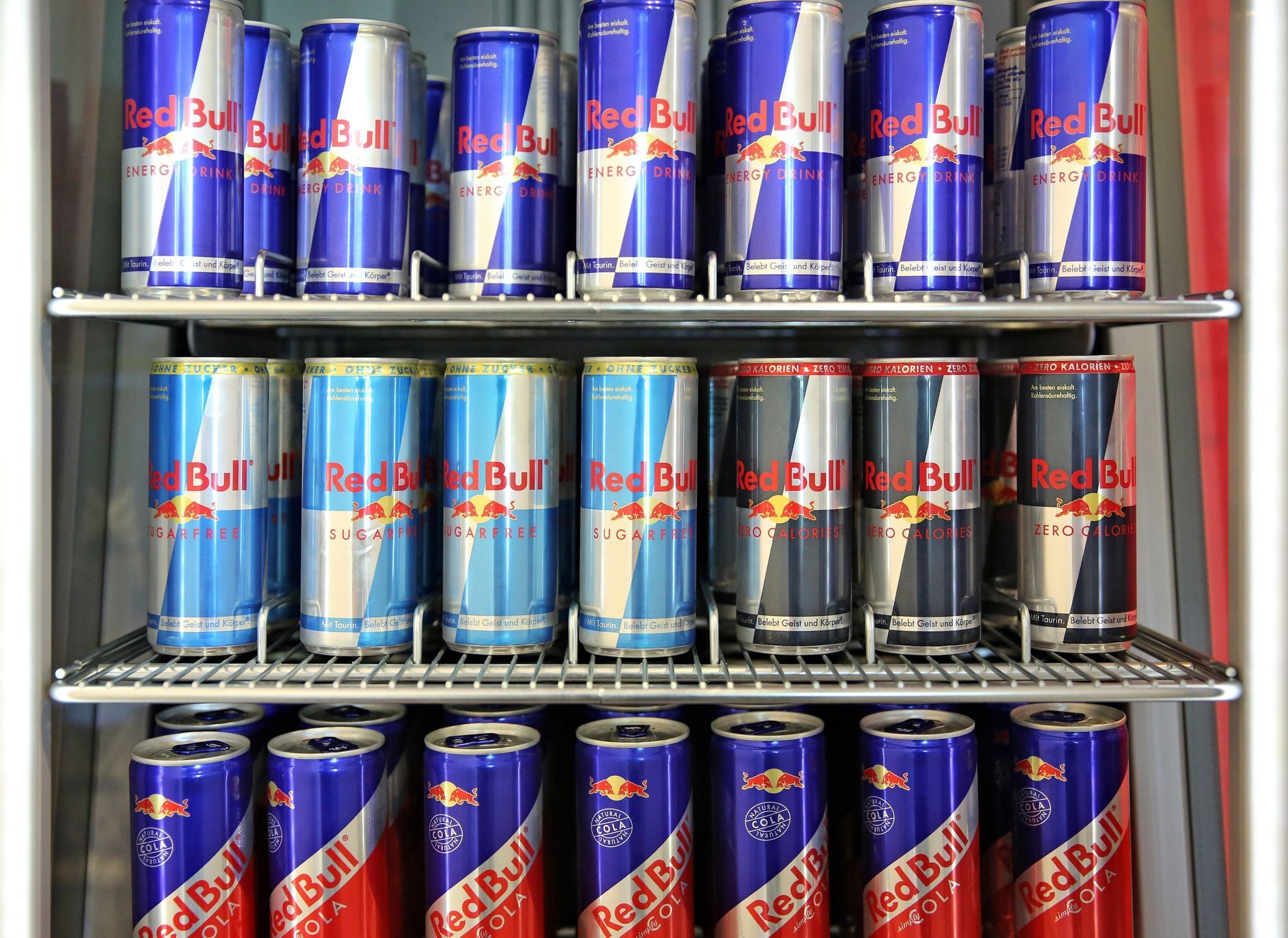 Ein Kühlschrank mit mehreren Dosen Red Bull Energy-Drinks in verschiedenen Sorten.