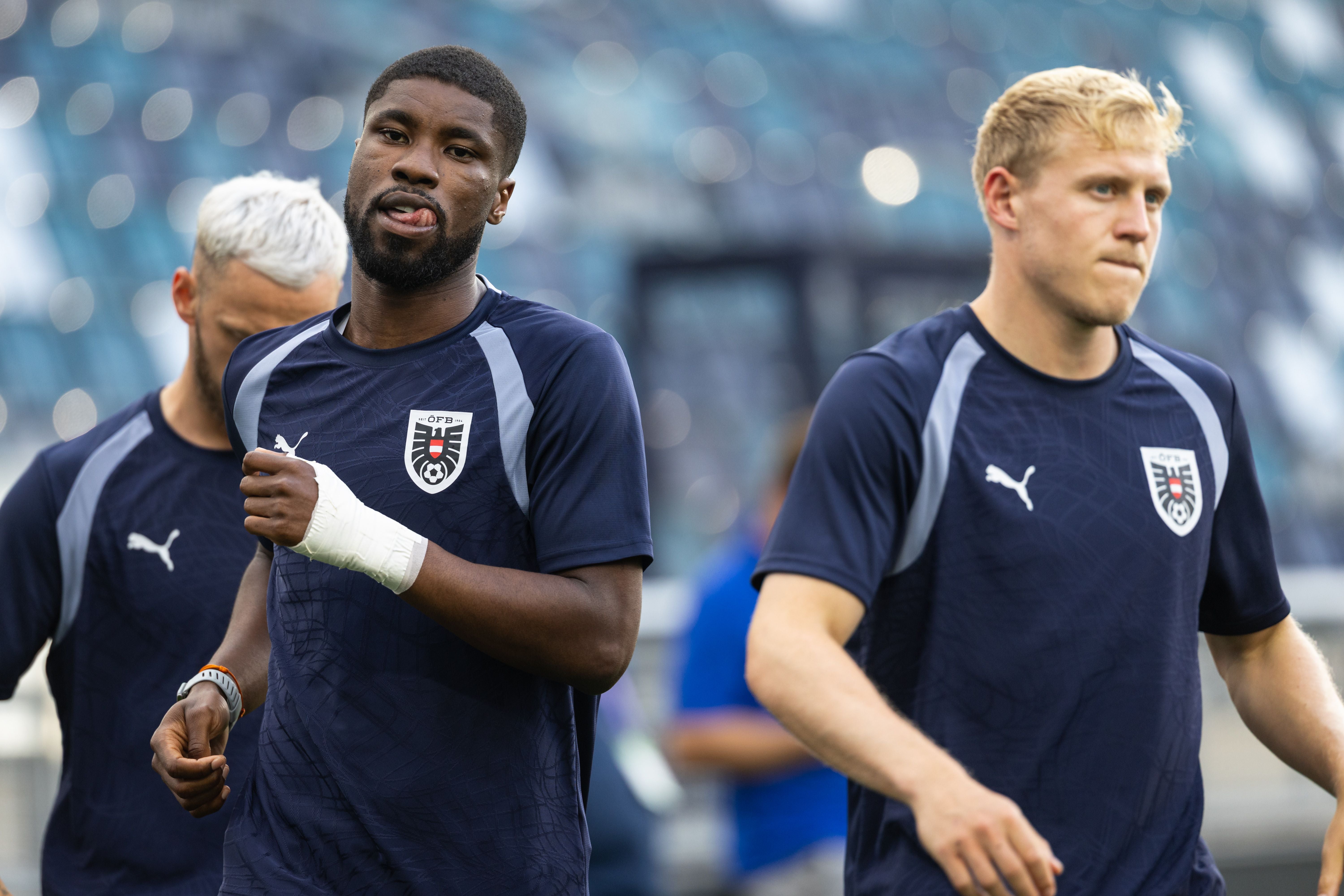 Drei österreichische Fußballspieler beim Training, alle tragen dunkelblaue Trikots mit ÖFB-Logo.