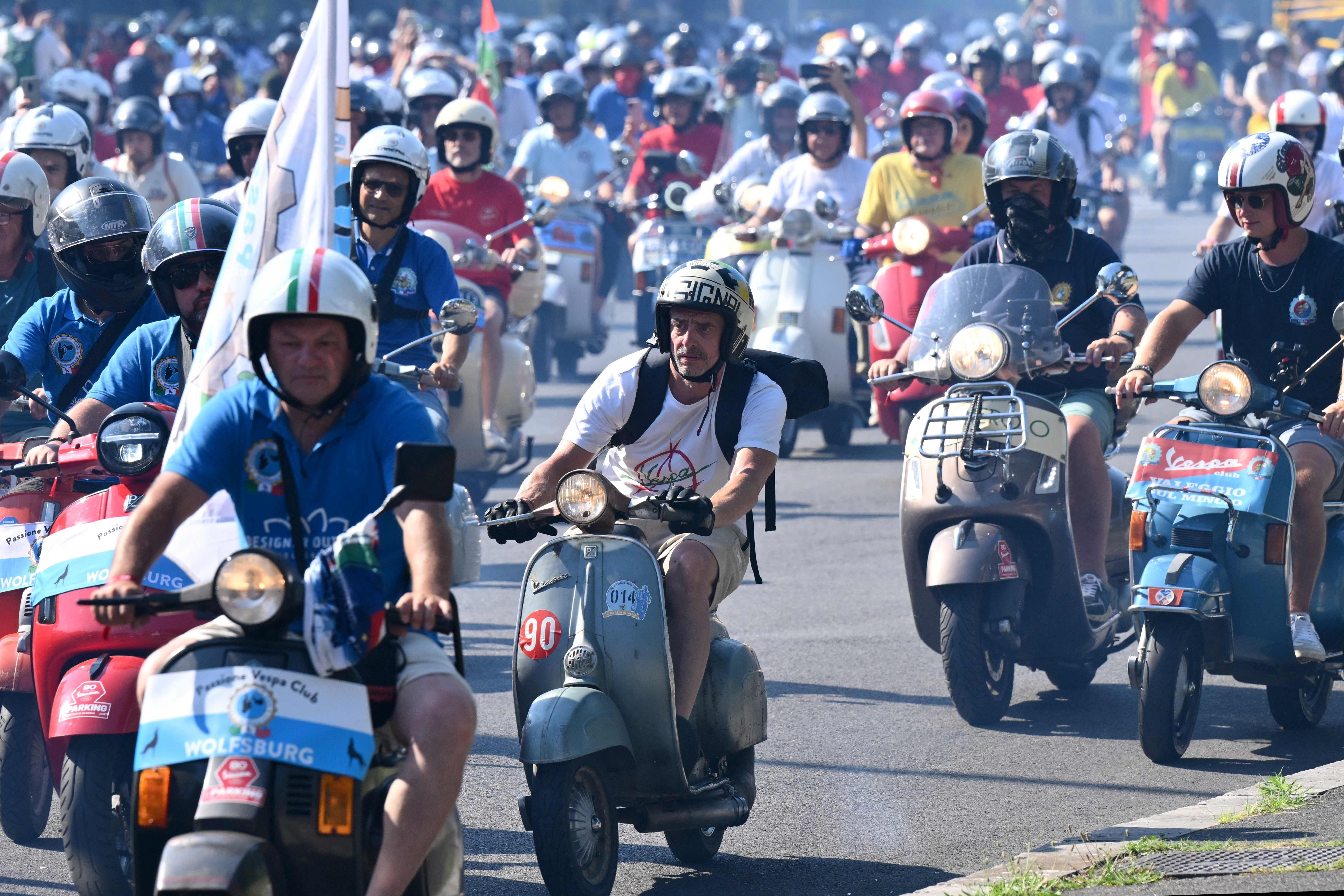 Viele Menschen fahren mit Vespas bei einer Parade zum 80-jährigen Jubiläum in Rom.