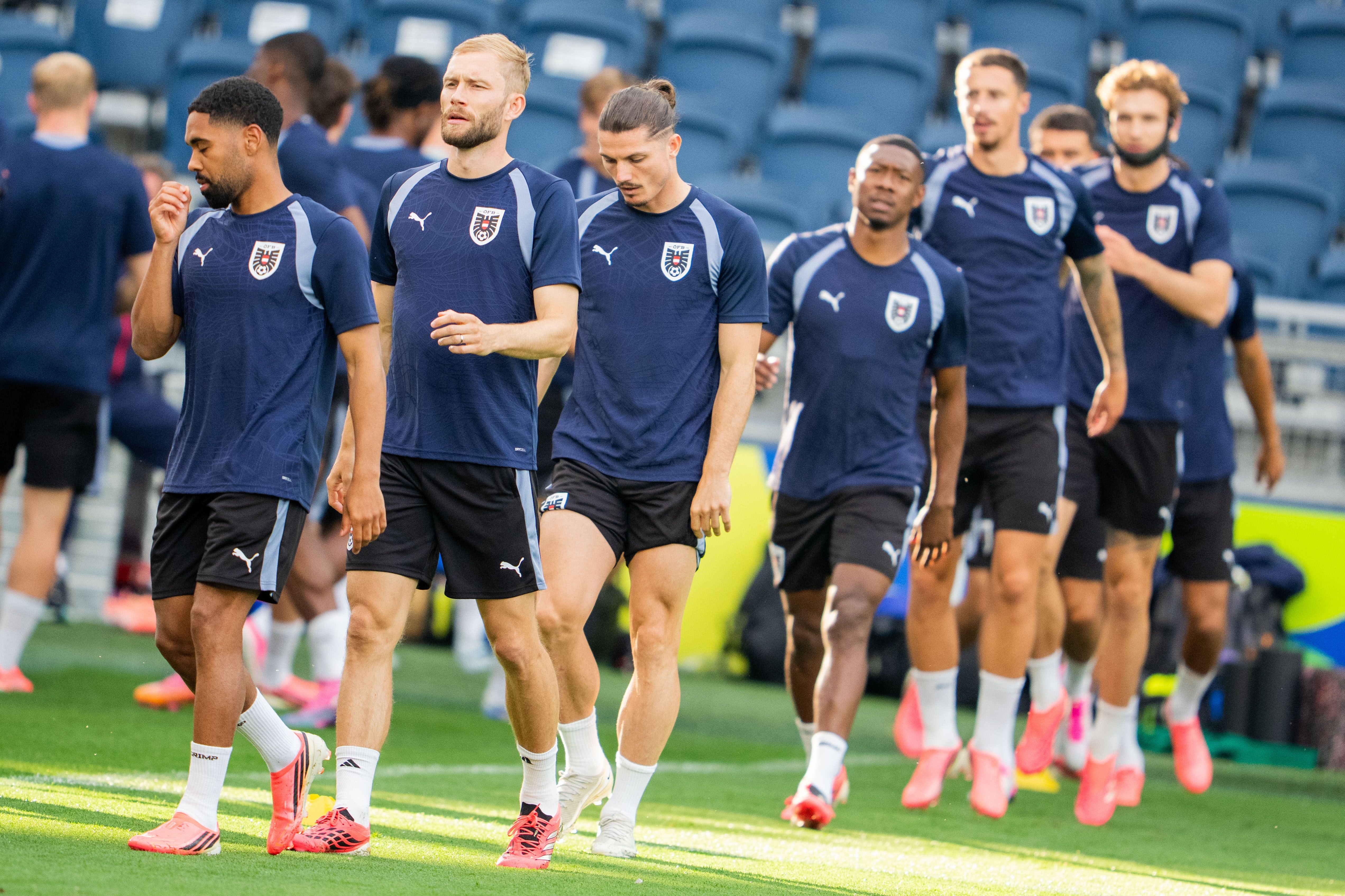 Mehrere österreichische Fußballspieler trainieren gemeinsam auf einem Stadionrasen.