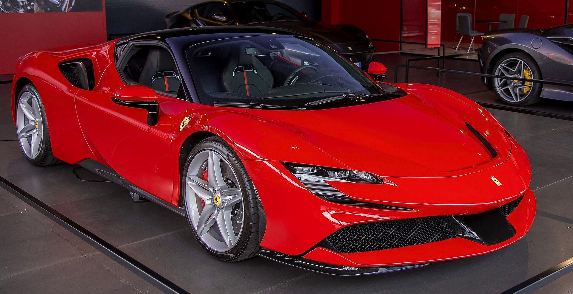 Roter Ferrari SF90 Stradale steht in einer Ausstellungshalle.