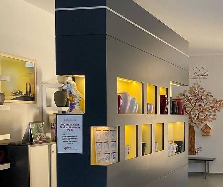 Modern eingerichteter Raum mit Urnenregalen und beleuchteten Nischen in einem Tierkrematorium.