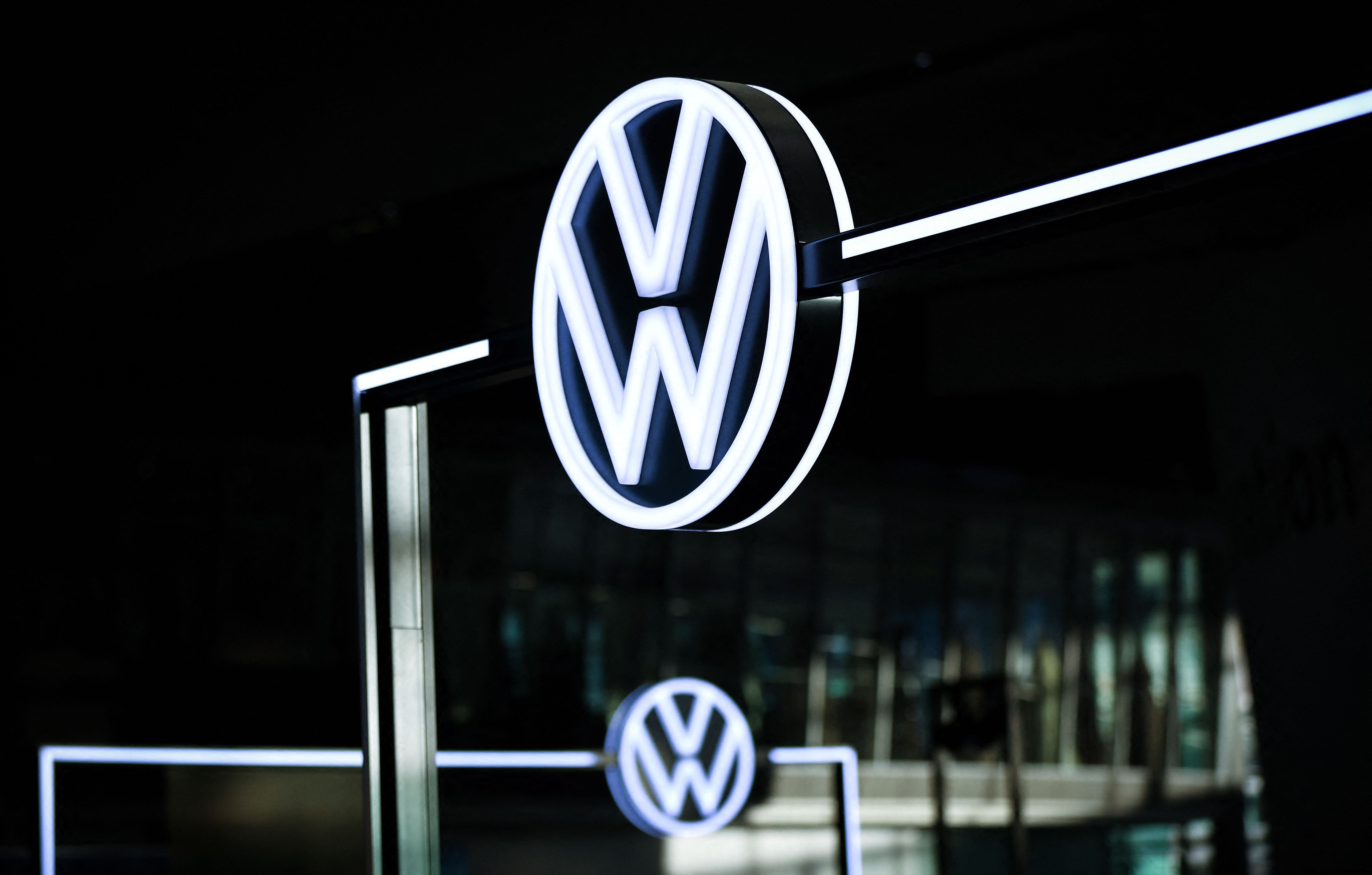Beleuchtetes VW-Logo im Kundenzentrum der Volkswagen-Zentrale in Wolfsburg bei Nacht.
