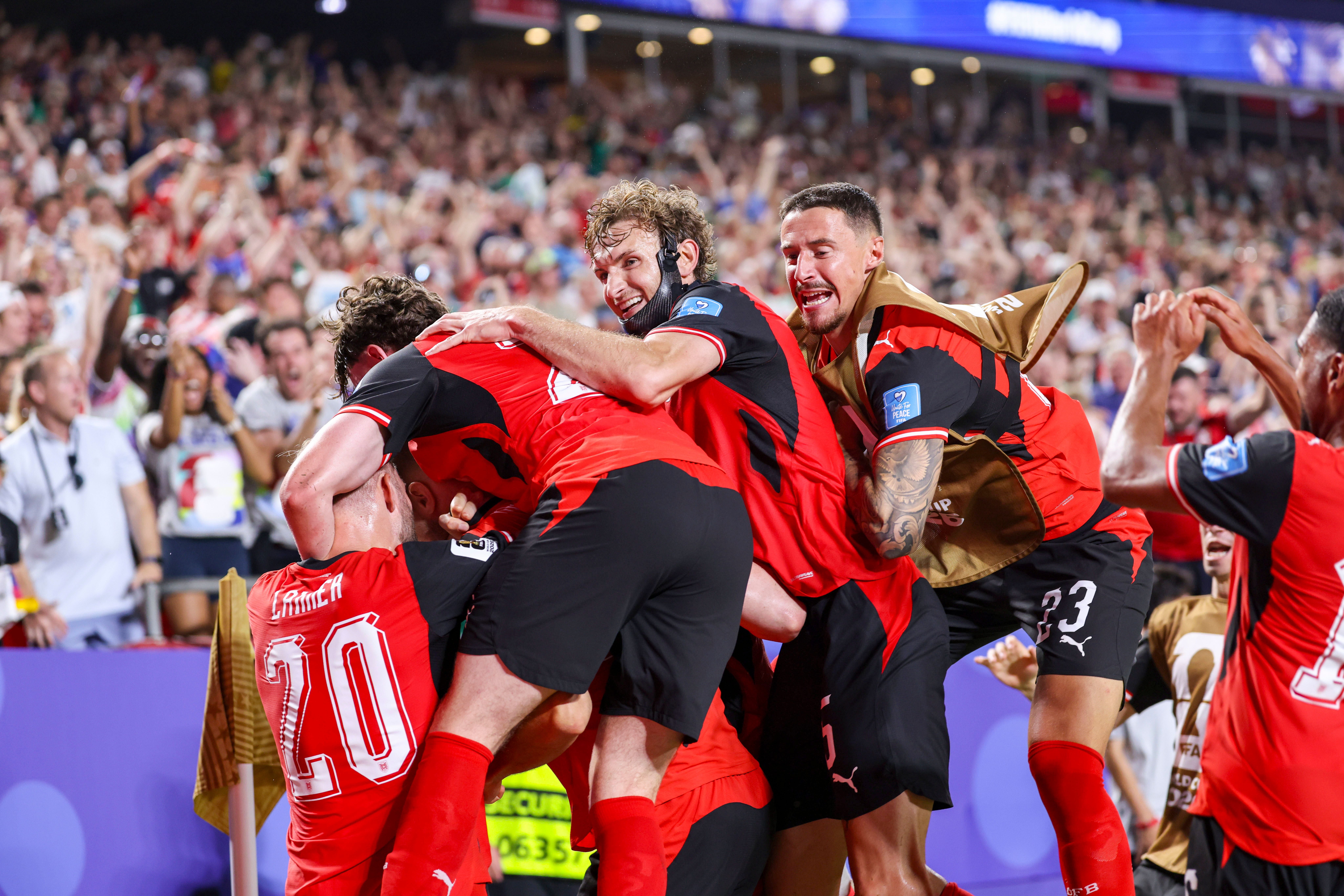 Österreichische Fußballspieler jubeln gemeinsam nach einem Tor vor jubelnden Fans im Stadion.