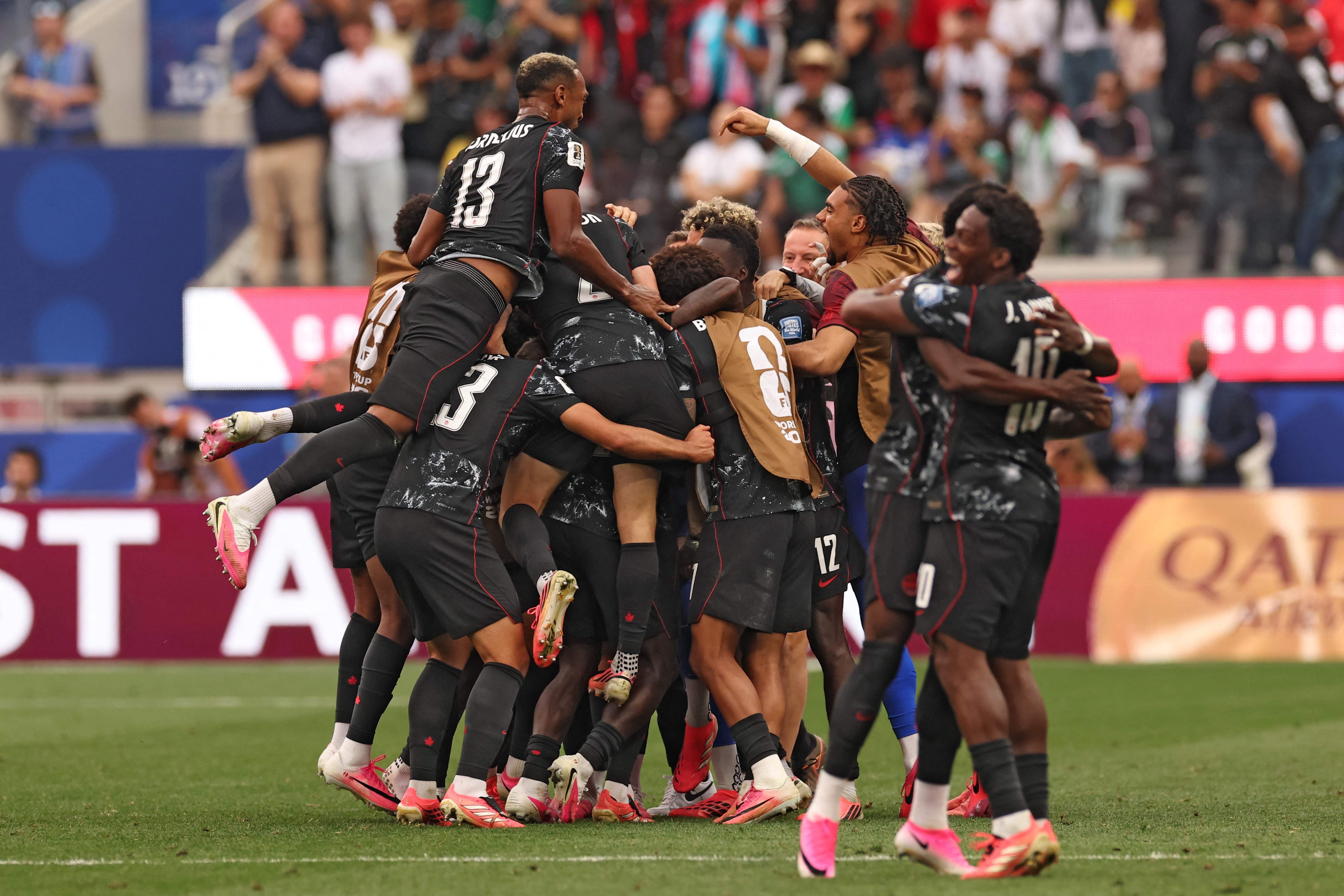 Kanadische Fußballspieler jubeln gemeinsam nach einem Tor in einem WM-Spiel im Stadion.