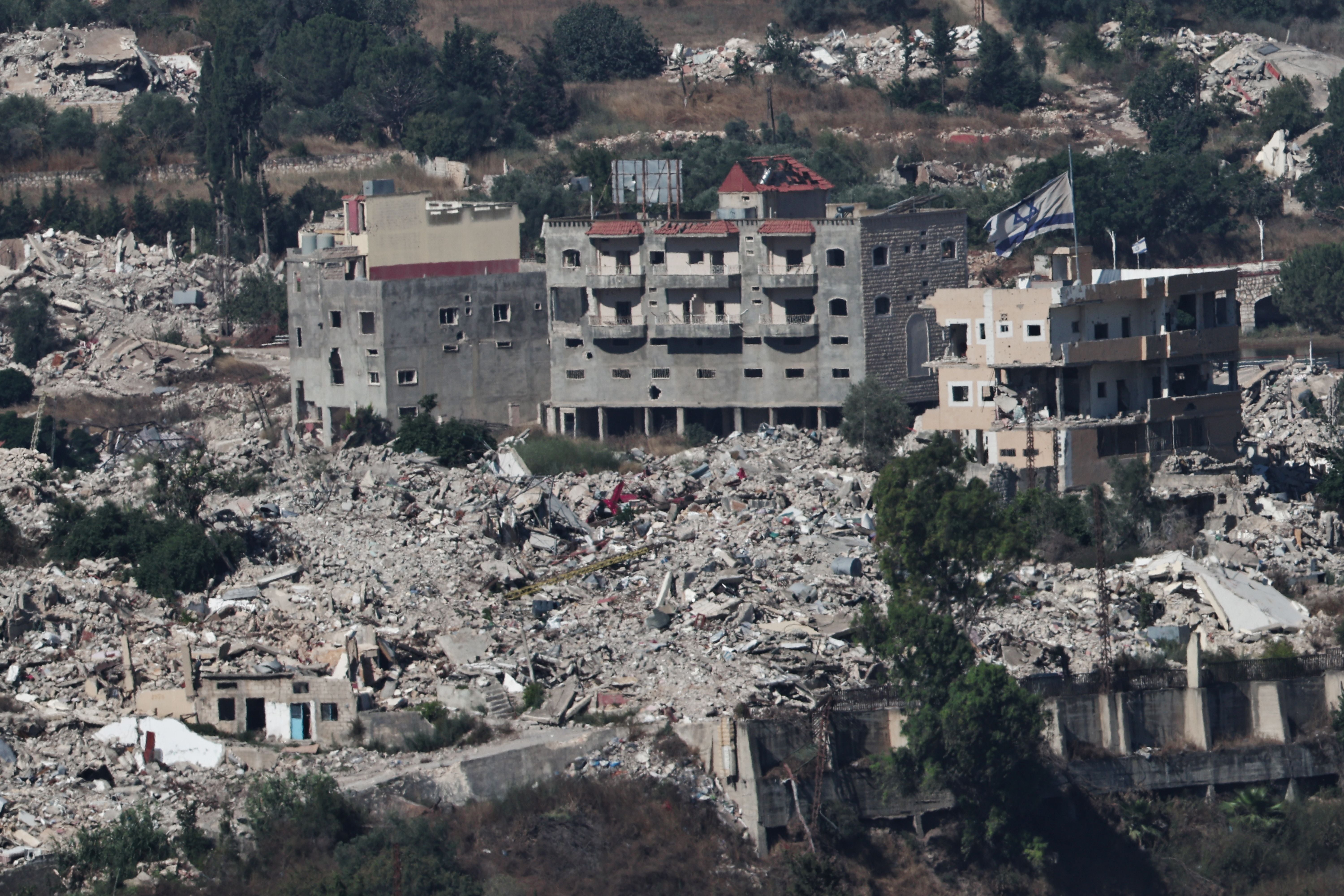 Zerstörte Gebäude und Trümmer mit einer israelischen Flagge auf einem Haus im Südlibanon.