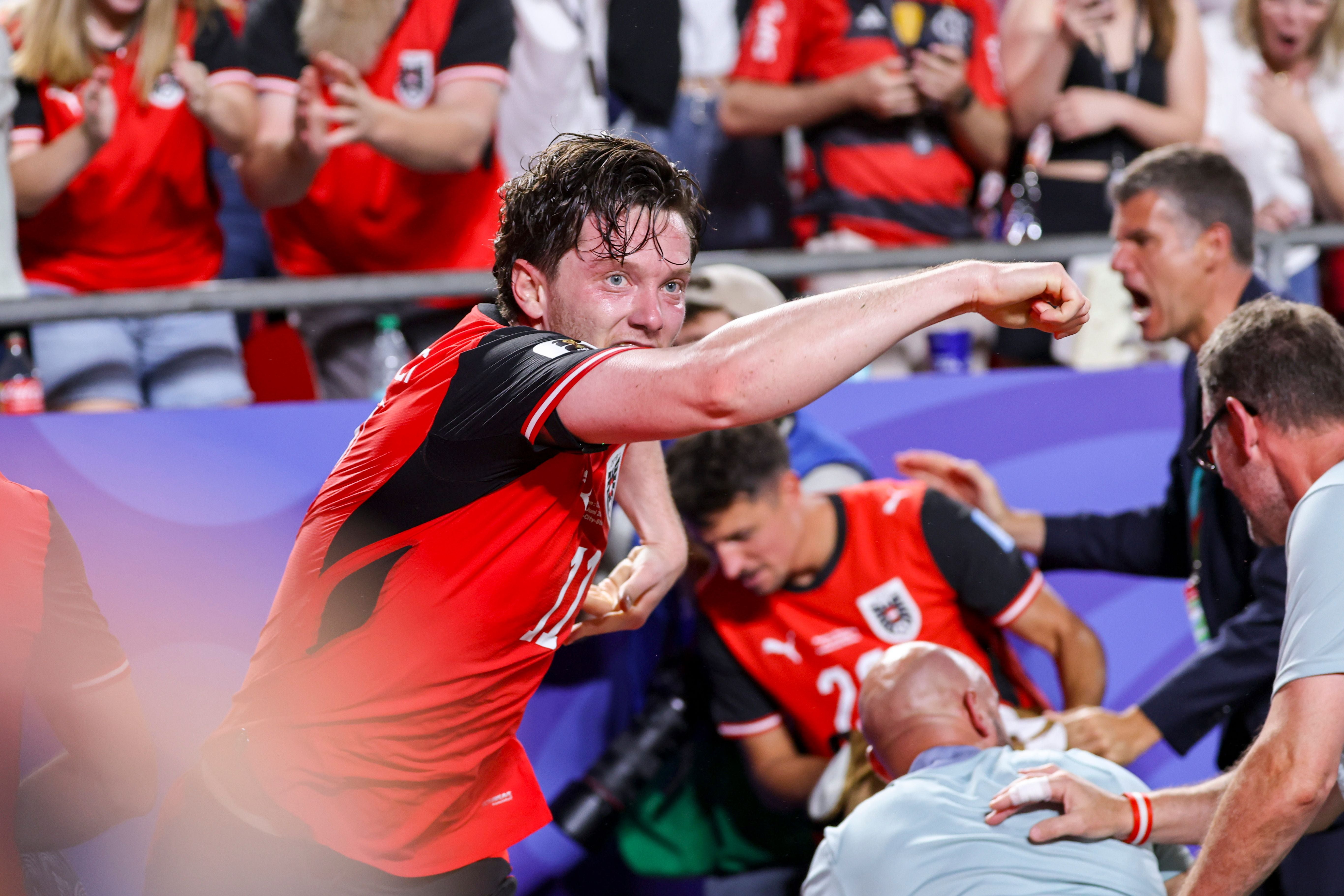 Michael Gregoritsch jubelt im rot-schwarzen Österreich-Trikot vor Fans und Teamkollegen.