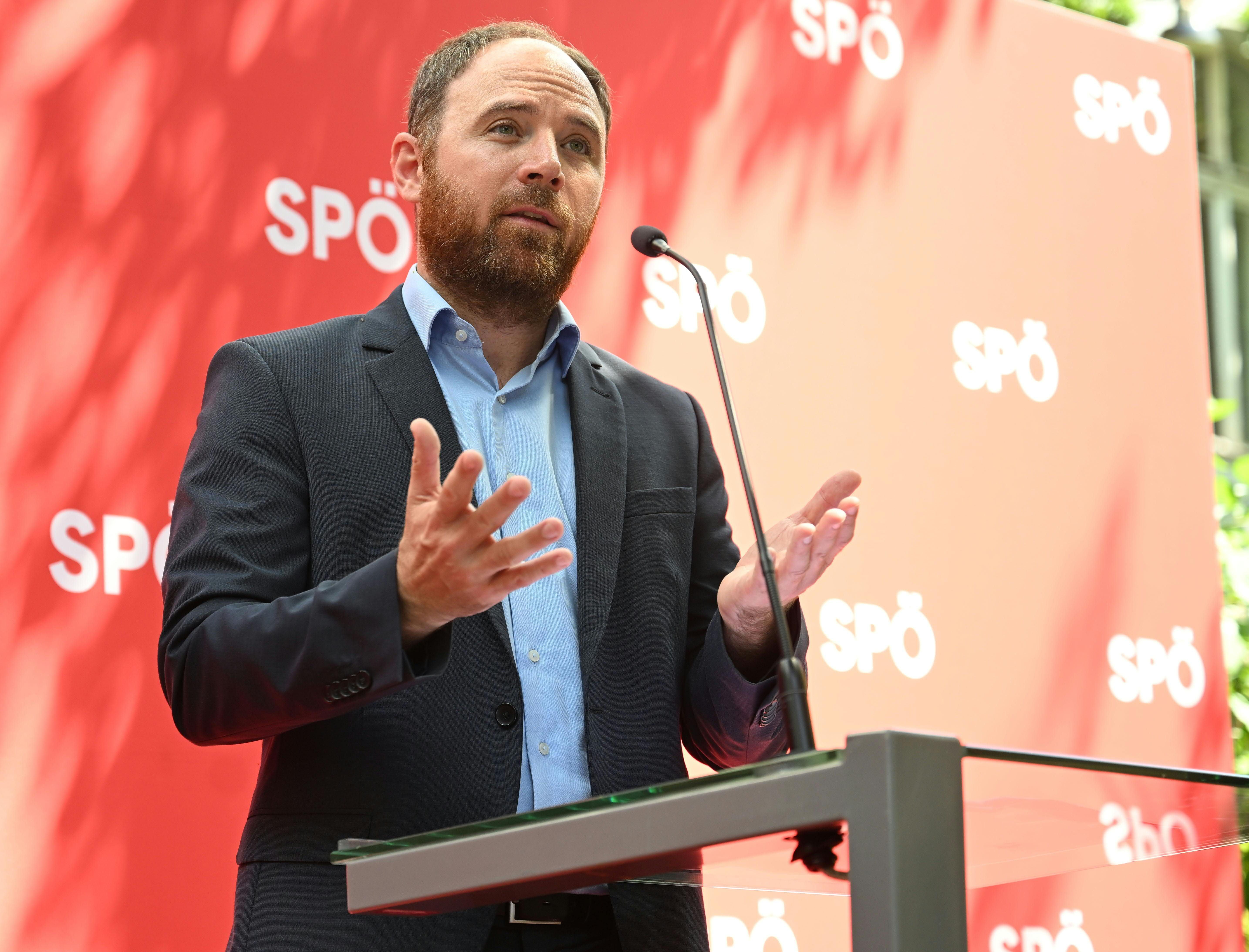 Ein Mann spricht bei einer Pressekonferenz am Rednerpult vor rotem Hintergrund mit SPÖ-Logos.
