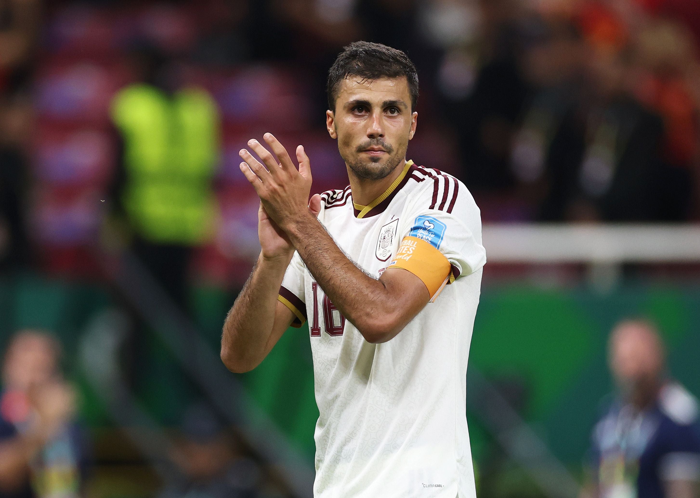 Ein spanischer Fußballspieler im weißen Trikot applaudiert nach einem Spiel im Stadion.