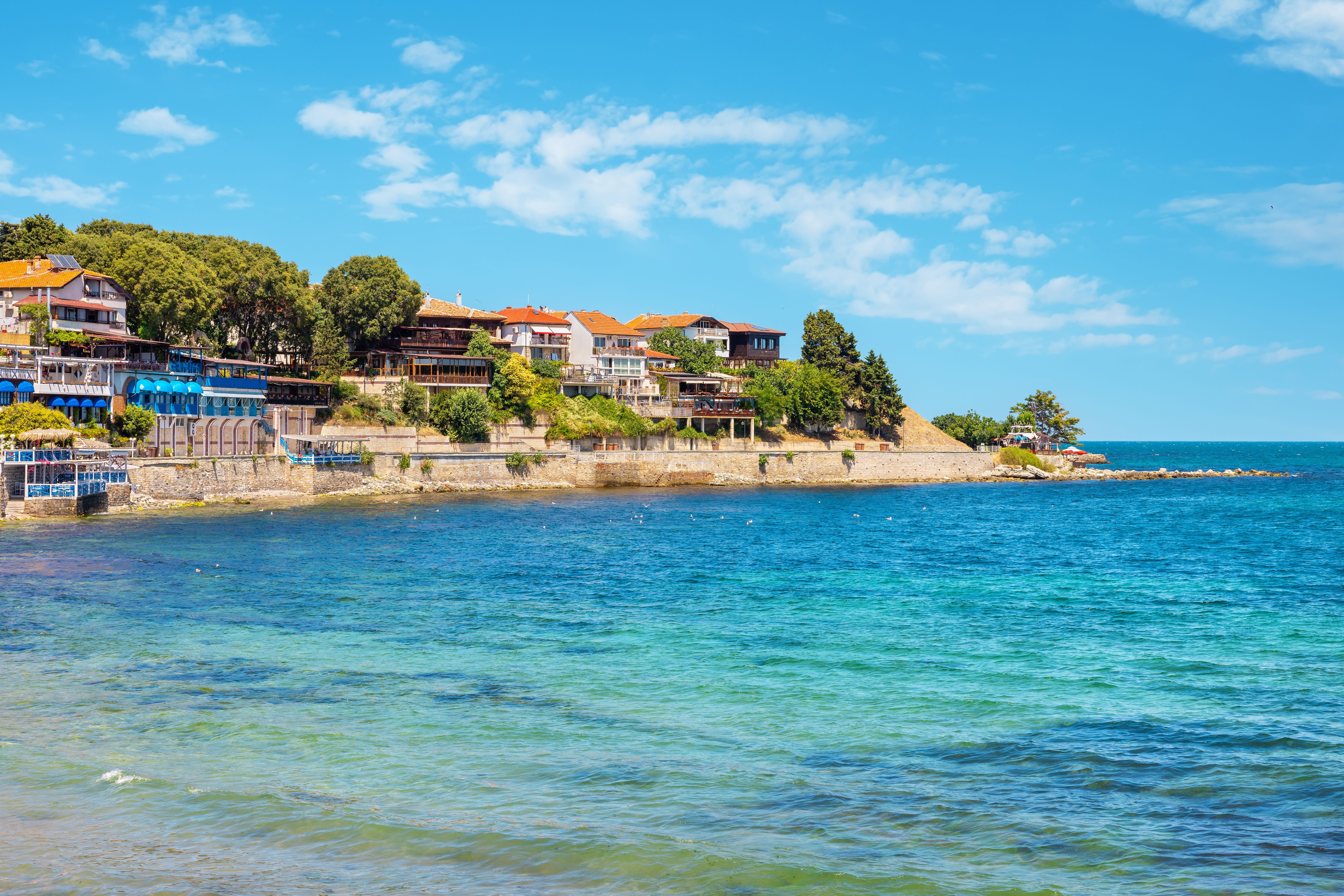 Blick auf die Küste der Altstadt von Nessebar mit Häusern und blauem Meer.