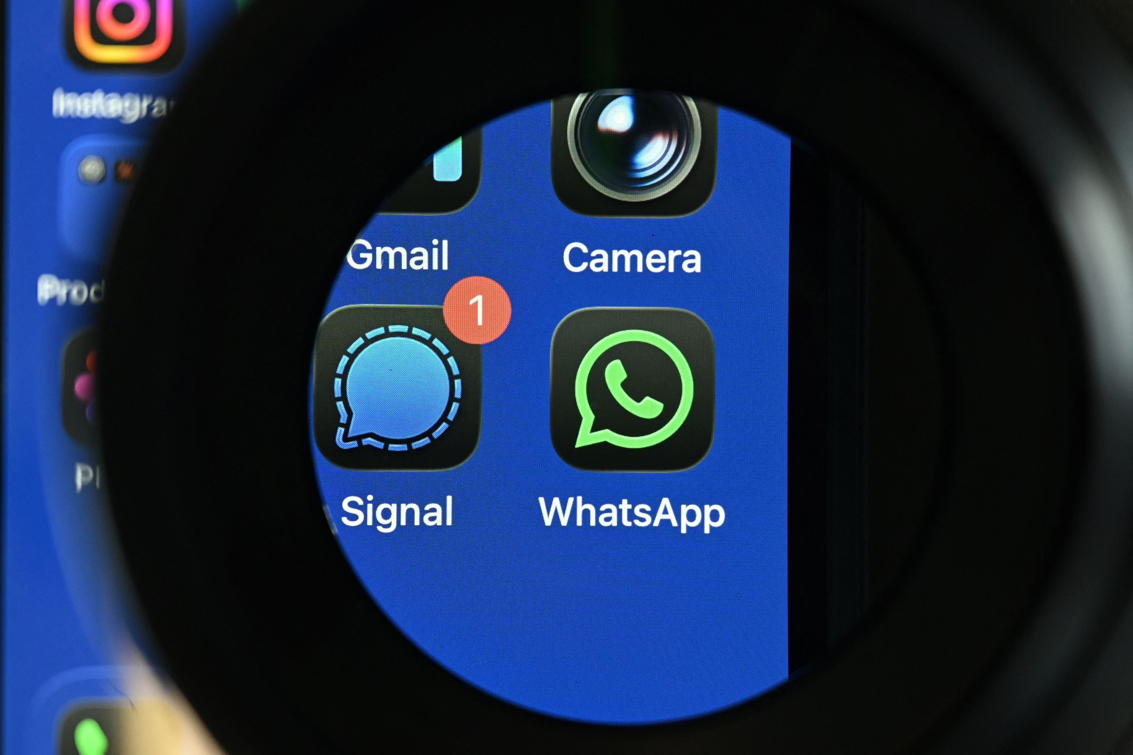 Signal- und WhatsApp-Logos auf einem Smartphone-Bildschirm, Signal zeigt eine neue Nachricht an.