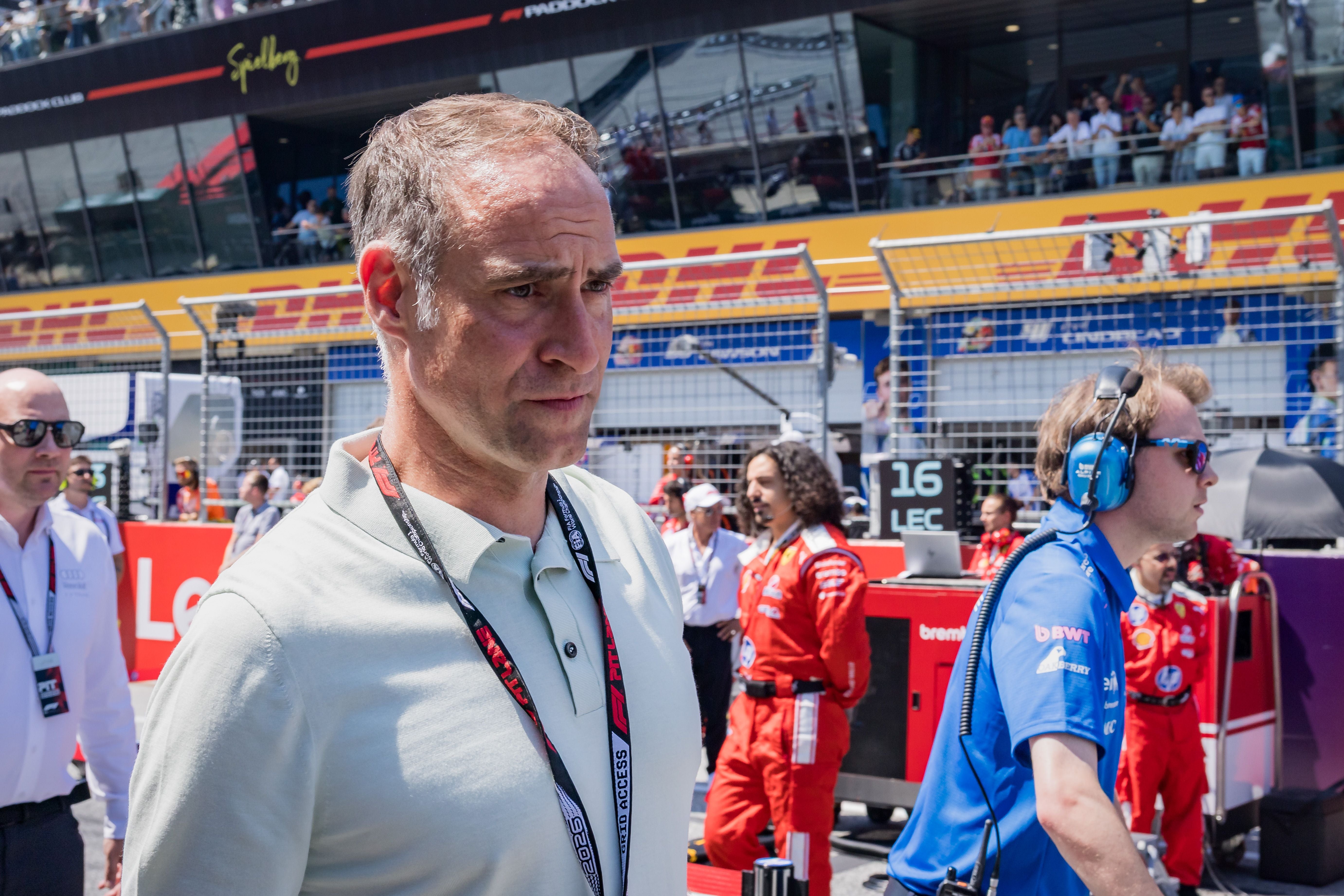Ein Mann mit Akkreditierungsausweis steht vor einer Rennstrecke beim Formel 1 Grand Prix in Spielberg.