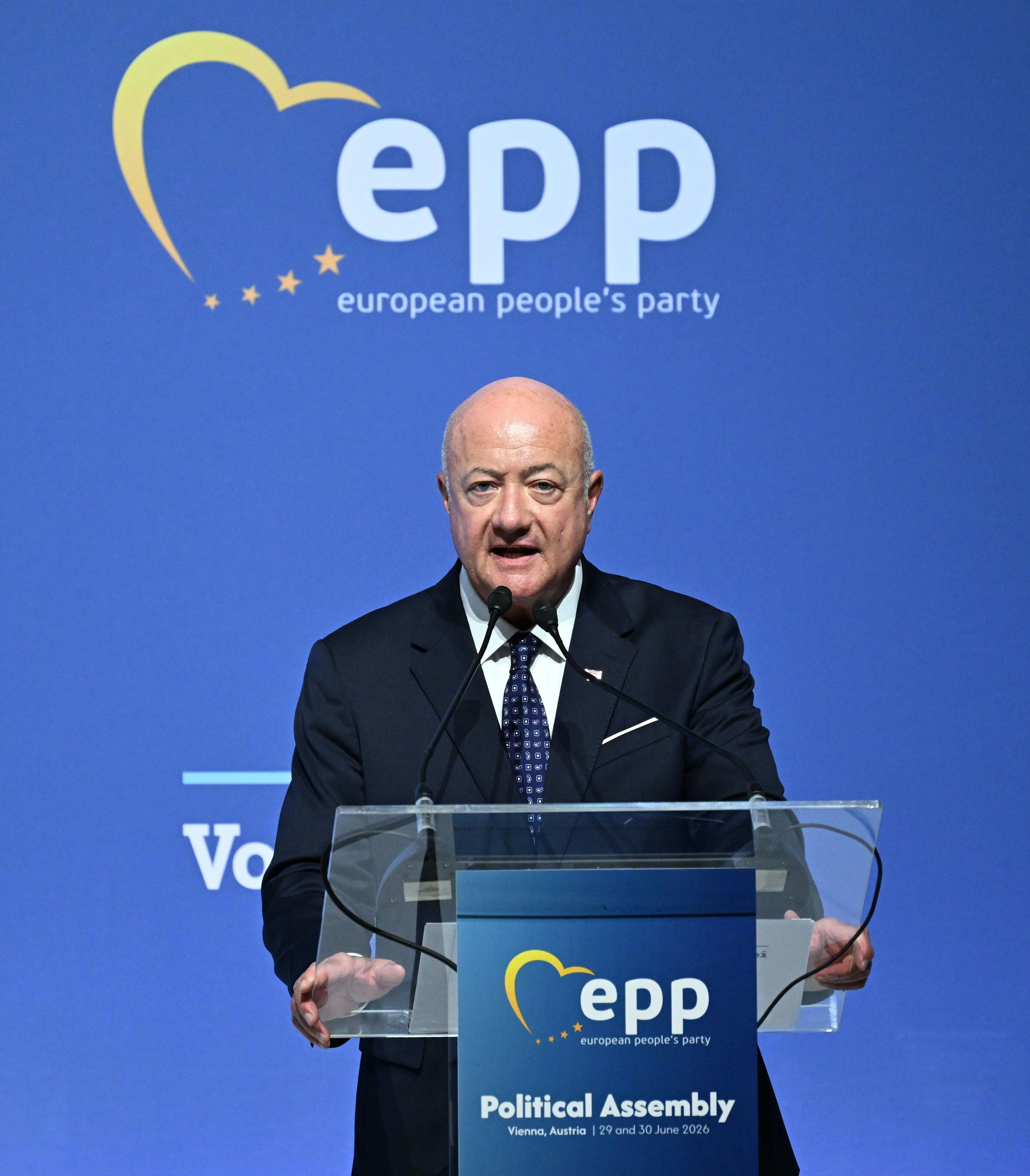 Ein Mann spricht bei einem EVP-Parteikongress am Rednerpult vor blauem Hintergrund.