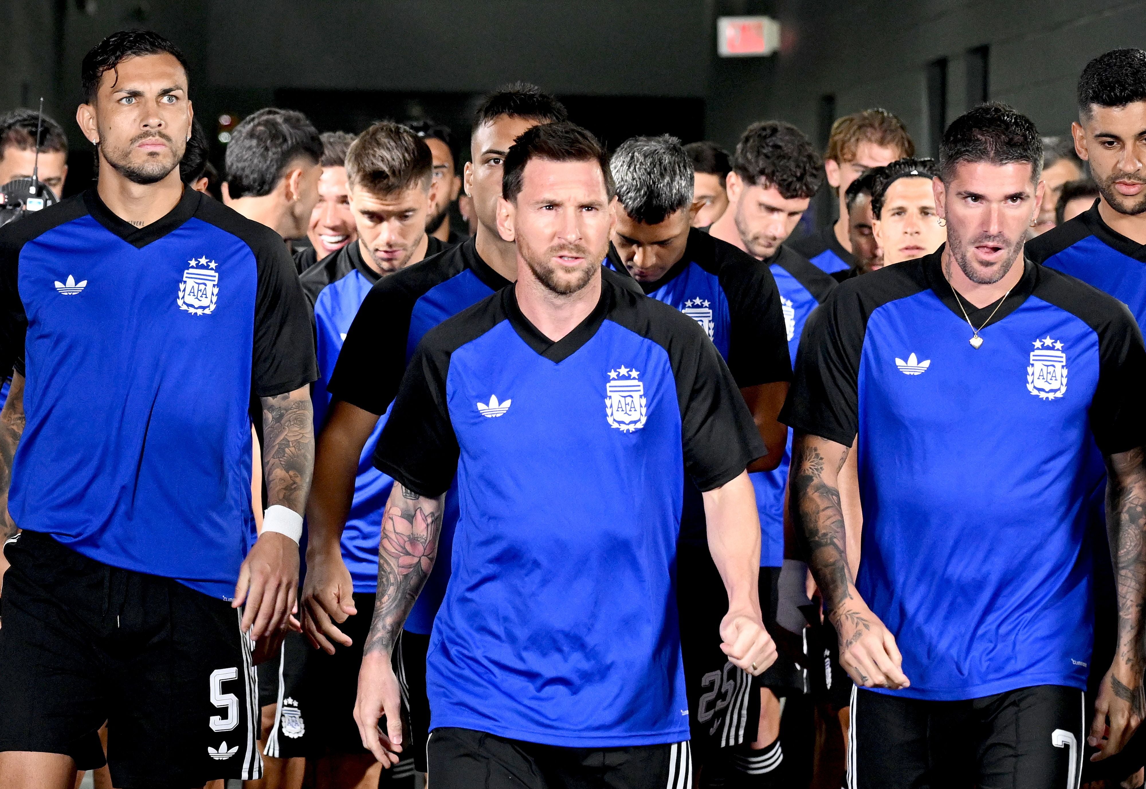Argentinische Fußballspieler betreten im blauen Aufwärmtrikot vor einem Spiel gemeinsam den Platz.