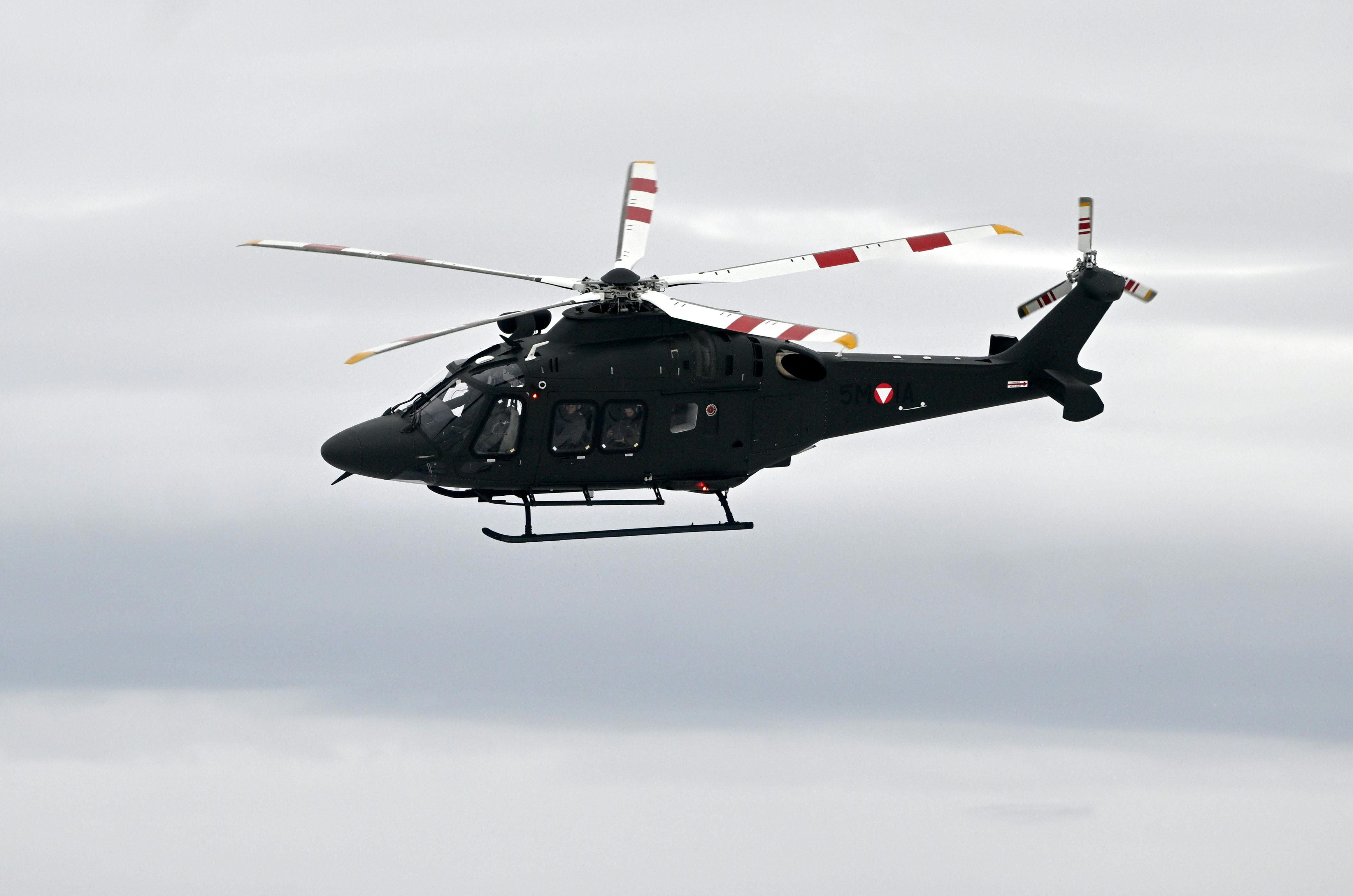 Ein schwarzer Mehrzweckhubschrauber Leonardo AW169M fliegt am Himmel bei bewölktem Wetter.