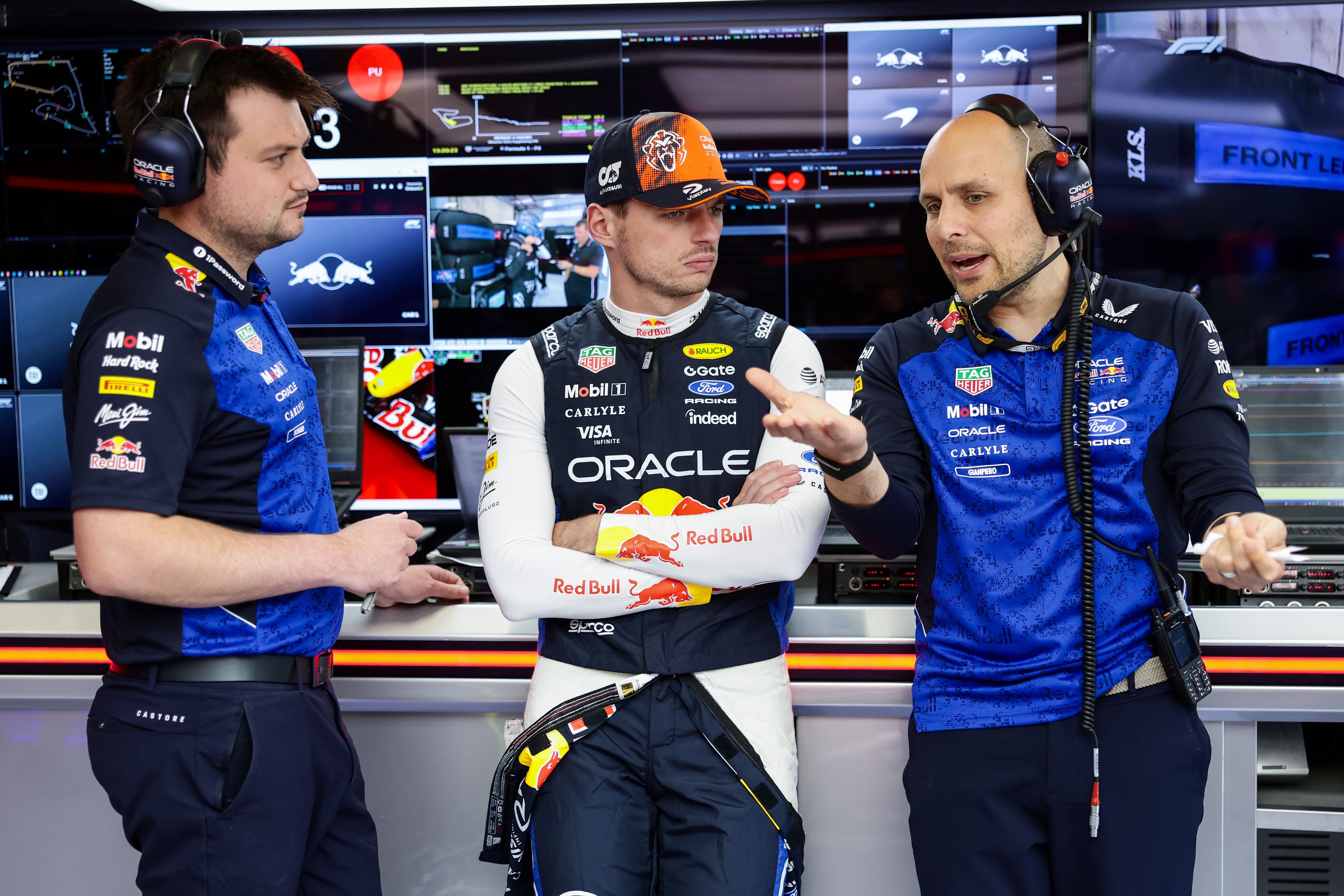 Drei Teammitglieder von Red Bull Racing sprechen in der Formel-1-Garage vor Monitoren.