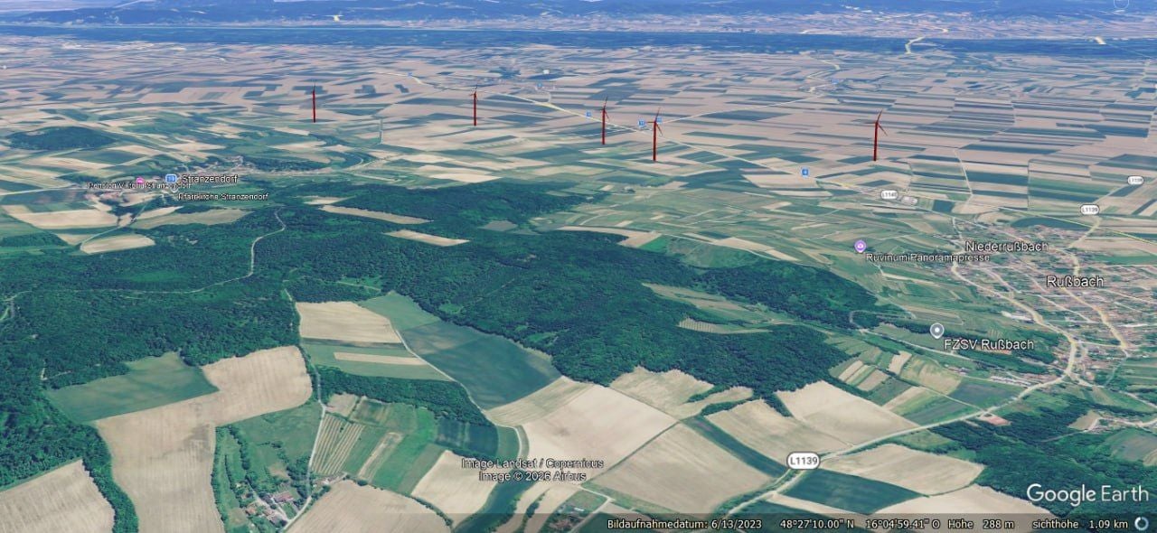 Landschaft mit mehreren fotomontierten Windrädern nahe Rußbach und umliegenden Feldern.