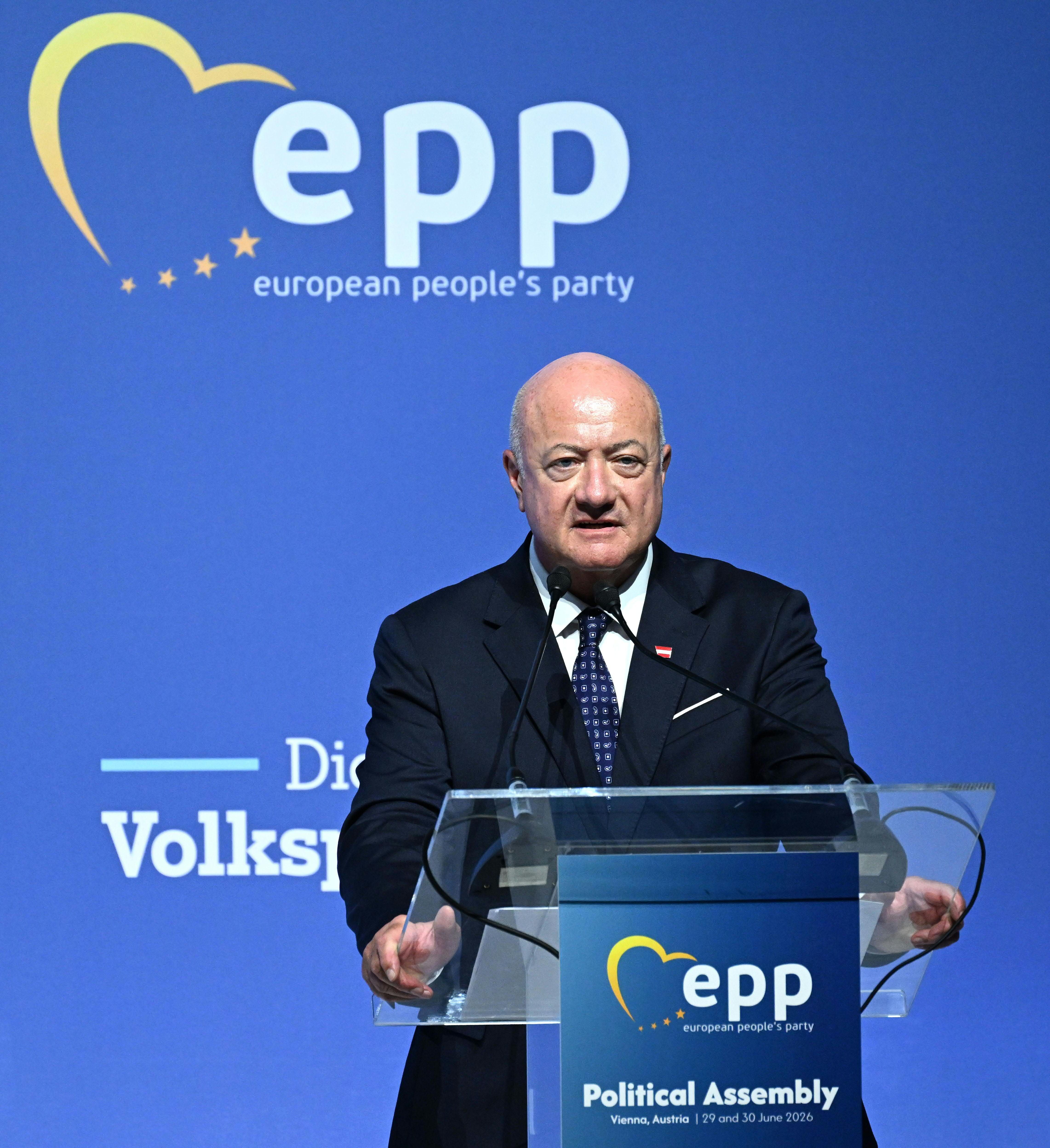 Ein Mann spricht am Rednerpult beim EVP-Parteikongress in Wien vor blauem Hintergrund.