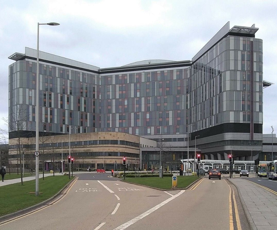 Modernes mehrstöckiges Krankenhausgebäude mit Glasfassade in Glasgow bei bewölktem Himmel.