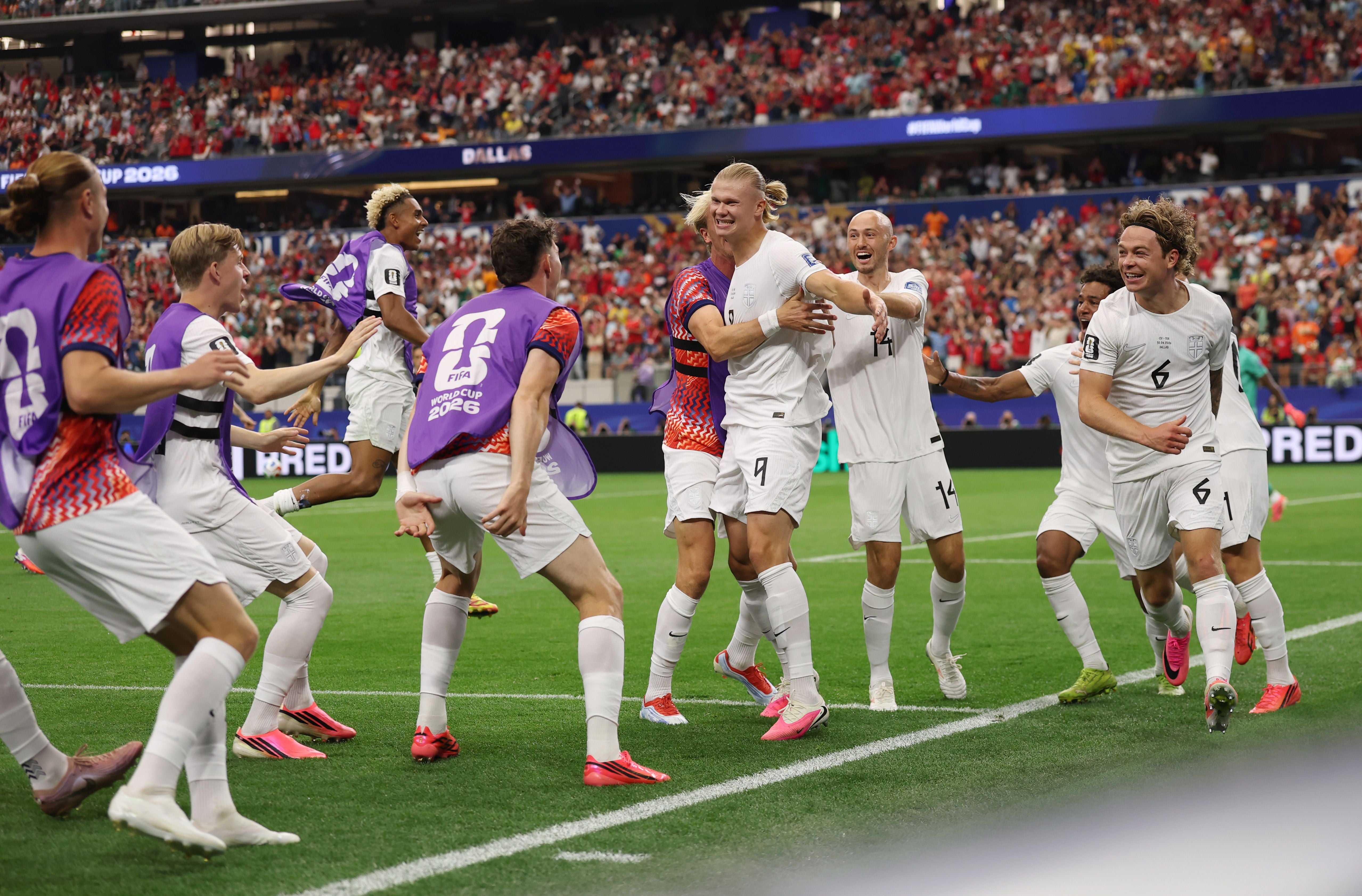 Norwegische Fußballspieler jubeln gemeinsam nach einem Tor während eines WM-Spiels im Stadion.