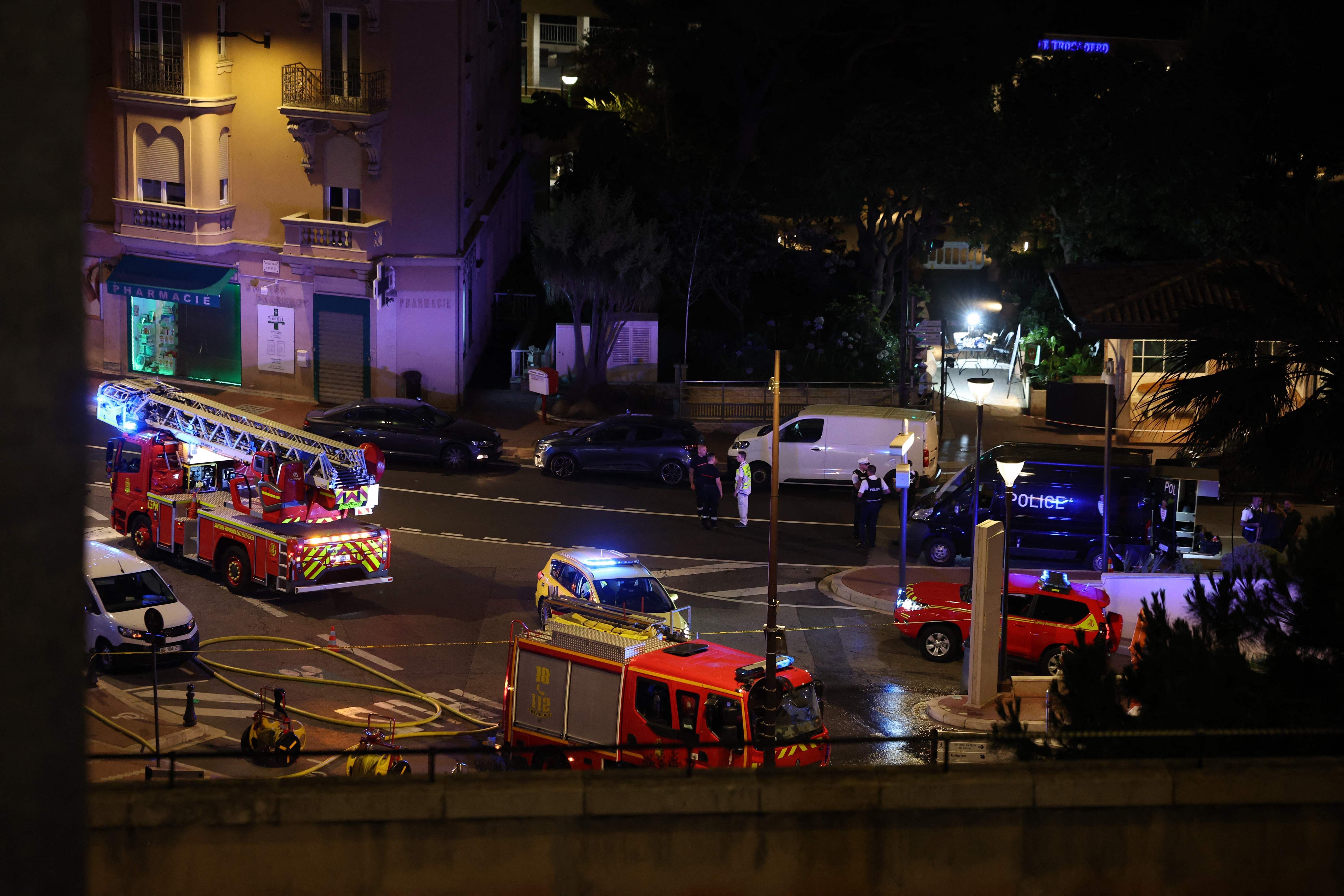 Mehrere Einsatzfahrzeuge mit Blaulicht stehen nachts an einer abgesperrten Straßenecke in Monaco.