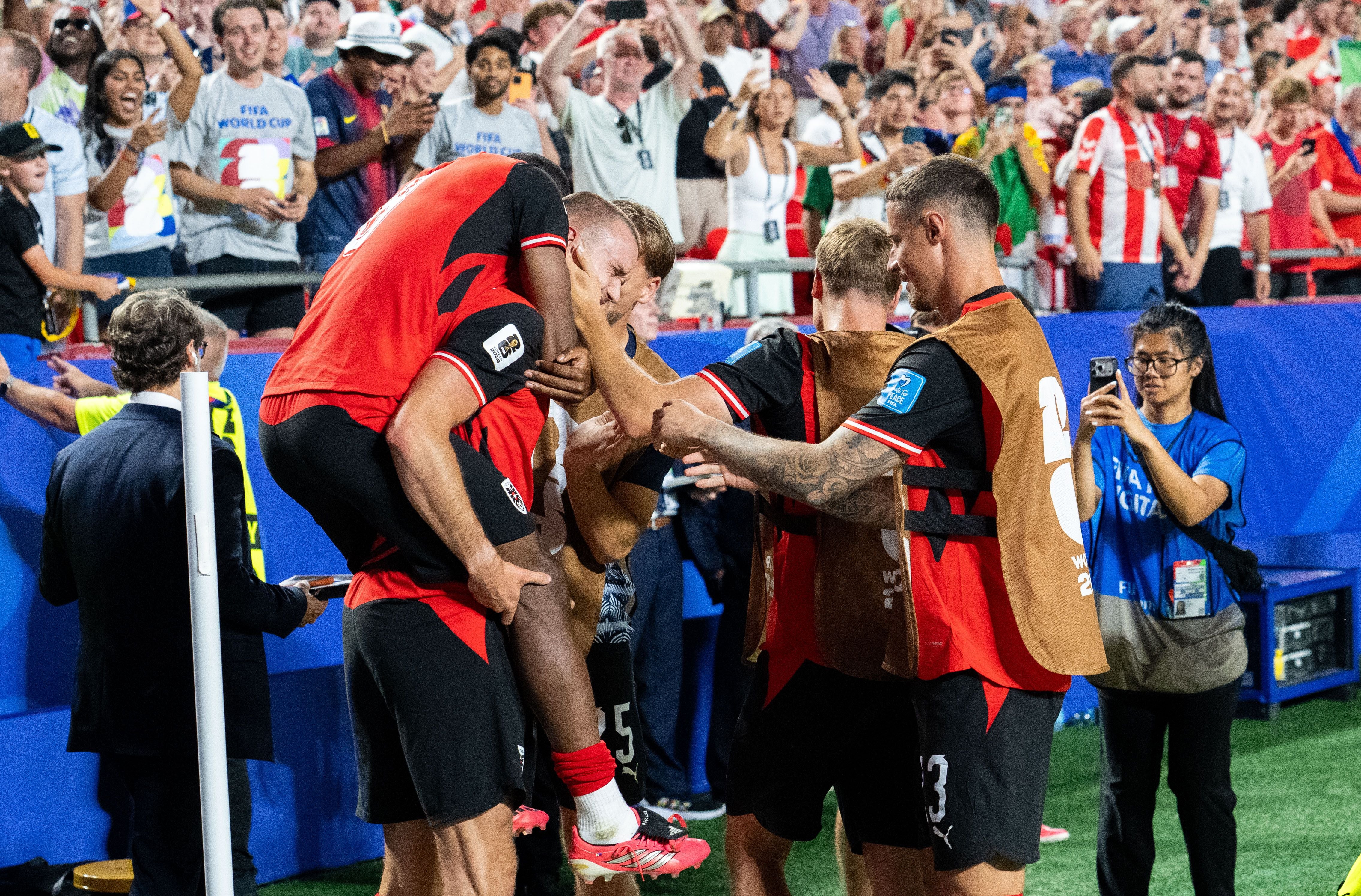 Österreichische Fußballspieler jubeln gemeinsam vor jubelnden Fans im Stadion bei der WM 2026.