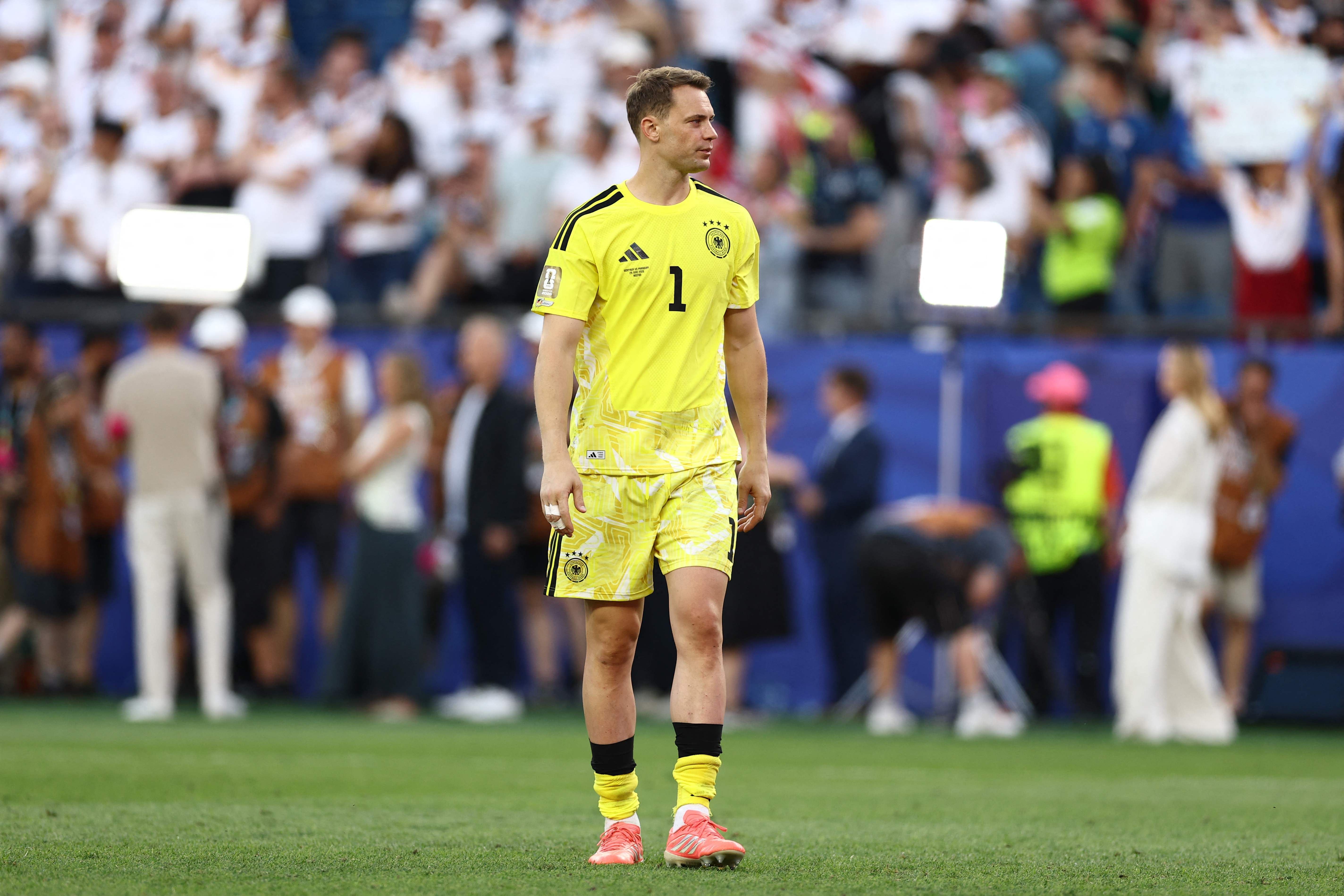 Ein deutscher Torwart im gelben Trikot steht enttäuscht auf dem Fußballfeld nach dem Spiel.