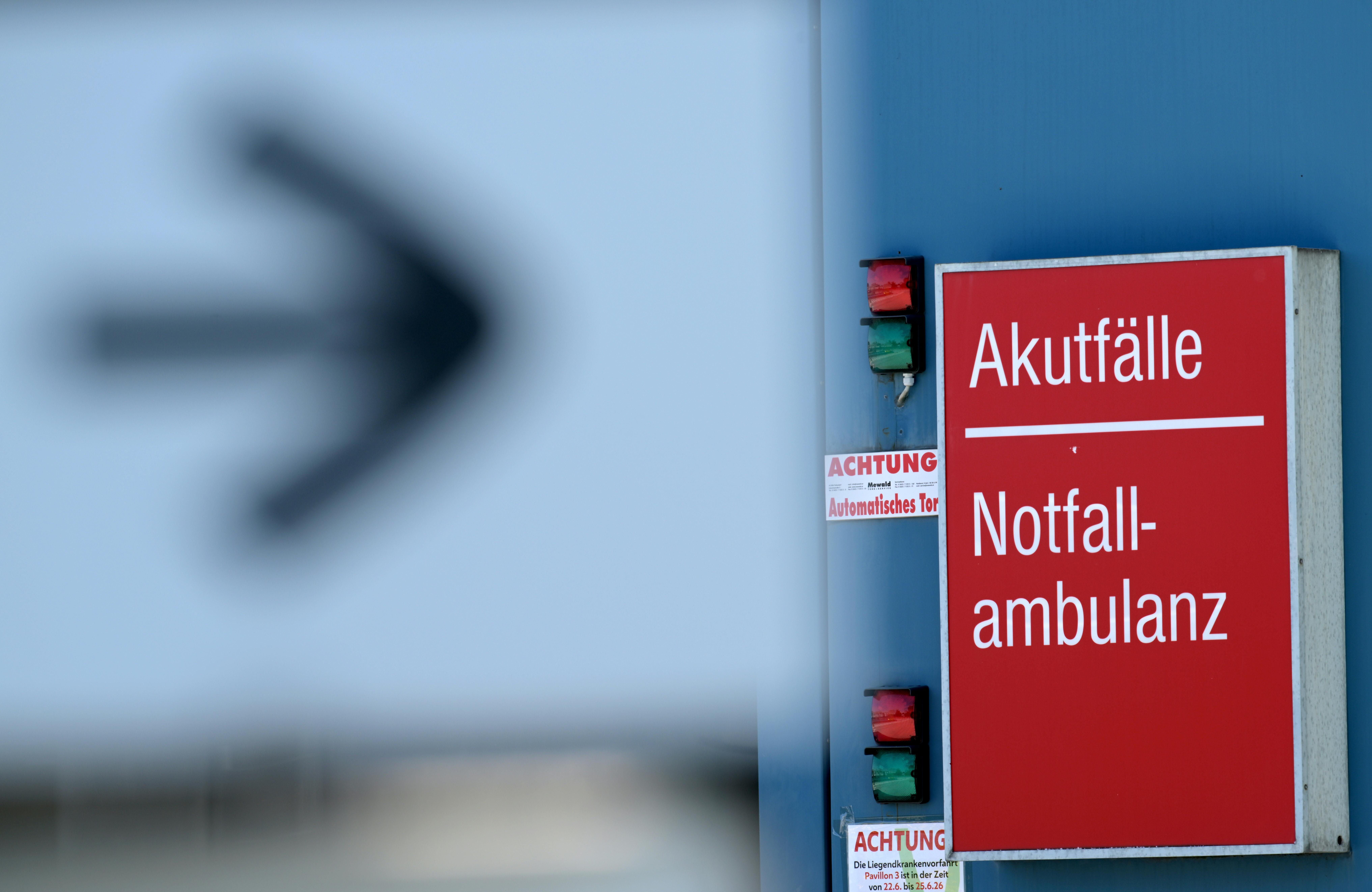 Hinweisschild „Akutfälle Notfallambulanz“ an einer Klinik, daneben ein Richtungspfeil.