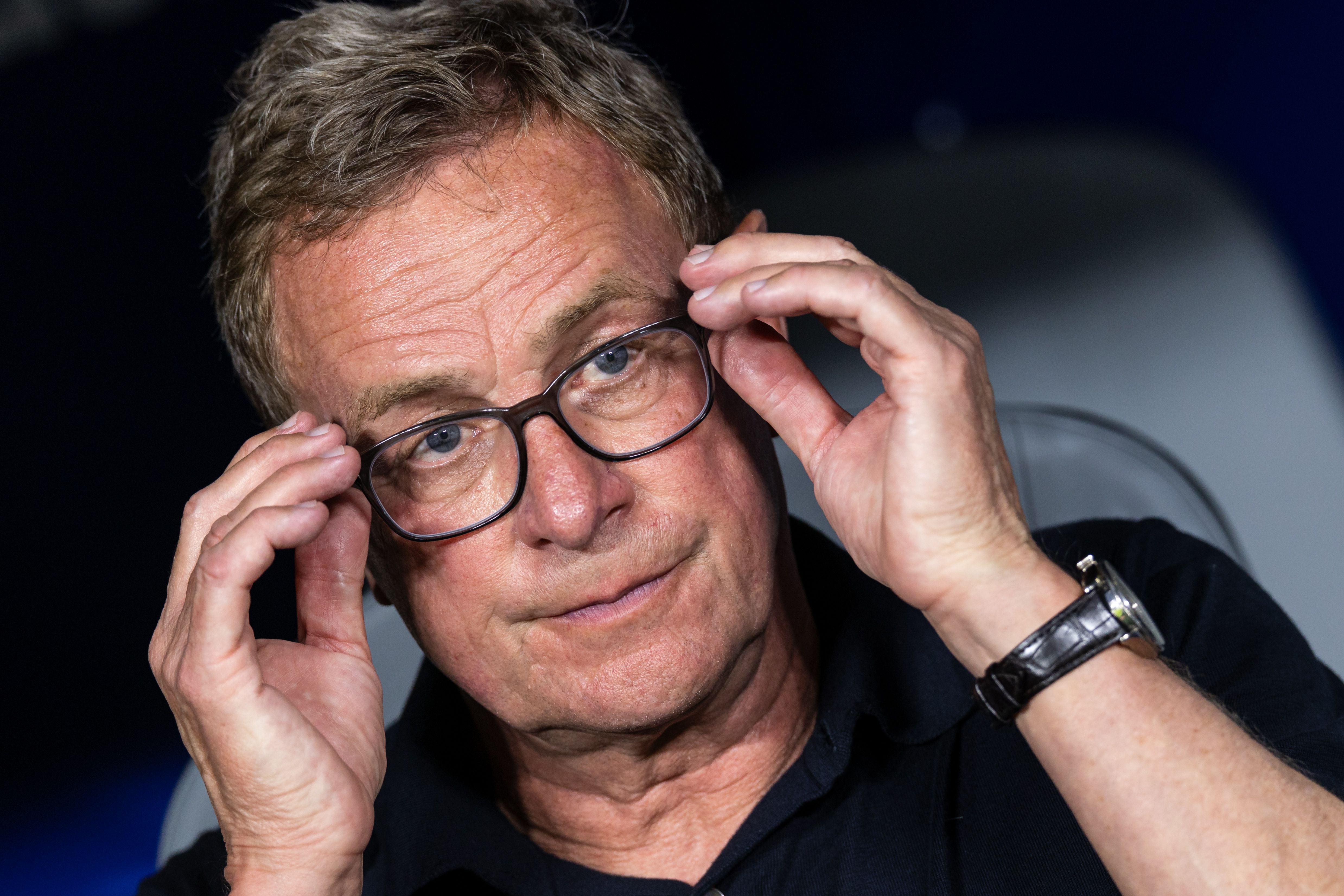 Ein Mann mit Brille richtet seine Brille und schaut nachdenklich in die Kamera.