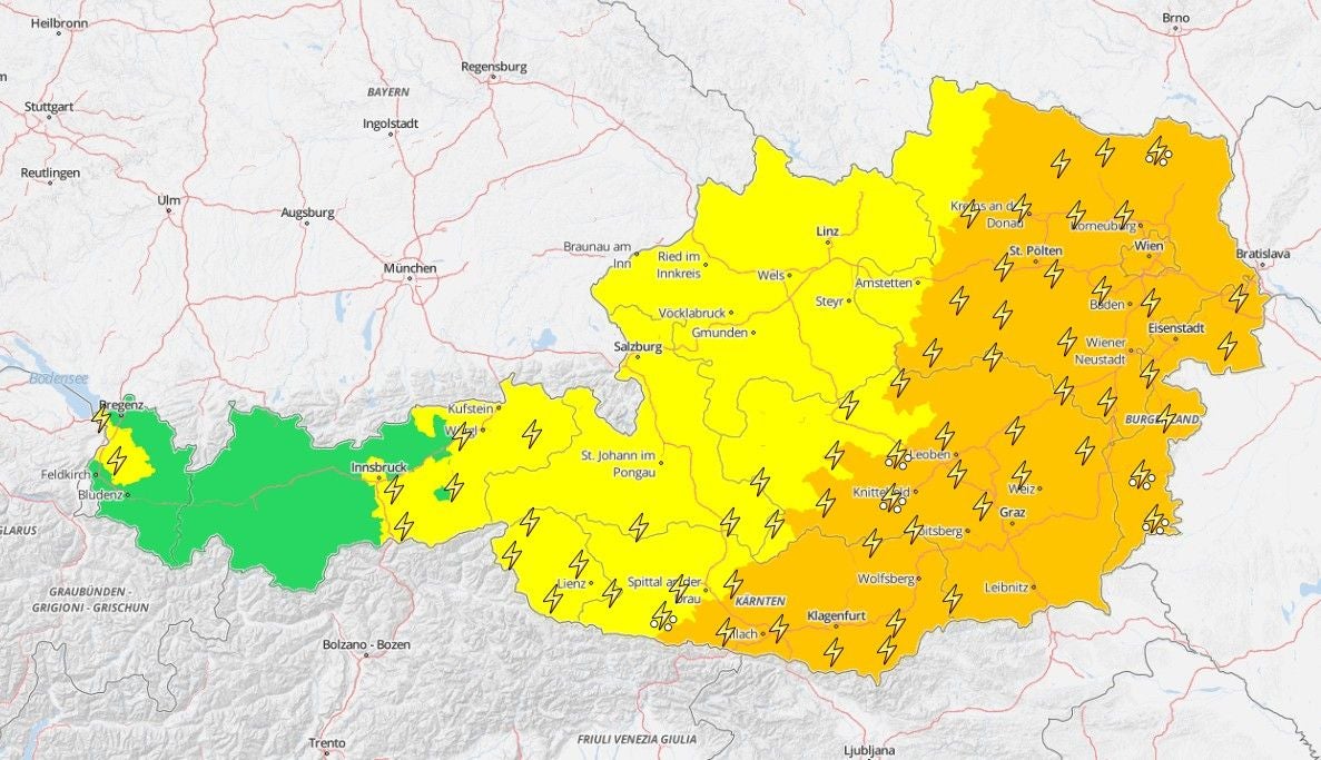 Unwetter-Warnkarte für Österreich mit farblich markierten Warnstufen und Blitzsymbolen.