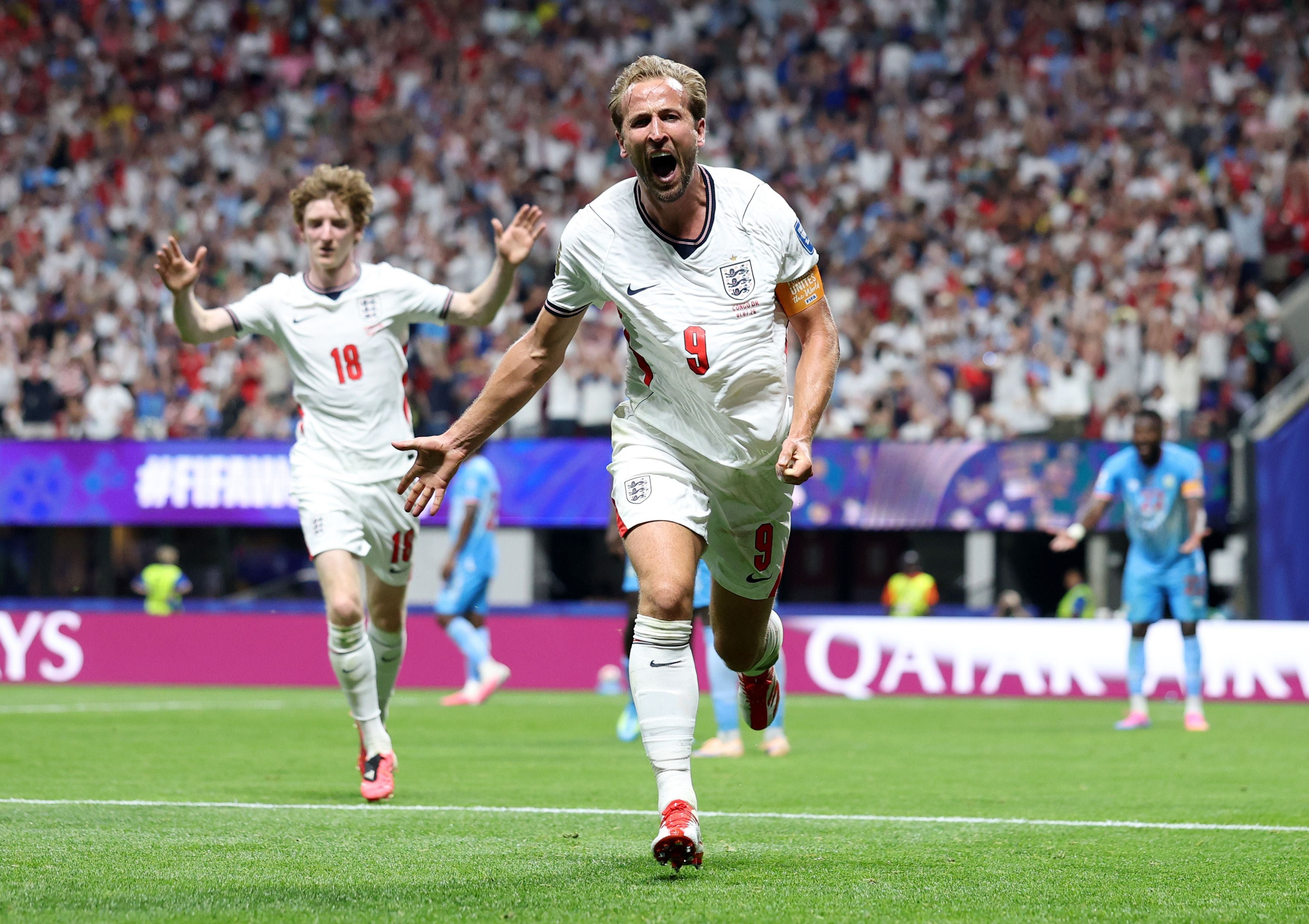 Englischer Fußballspieler jubelt nach einem Tor bei einem WM-Spiel, Zuschauer jubeln im Hintergrund.