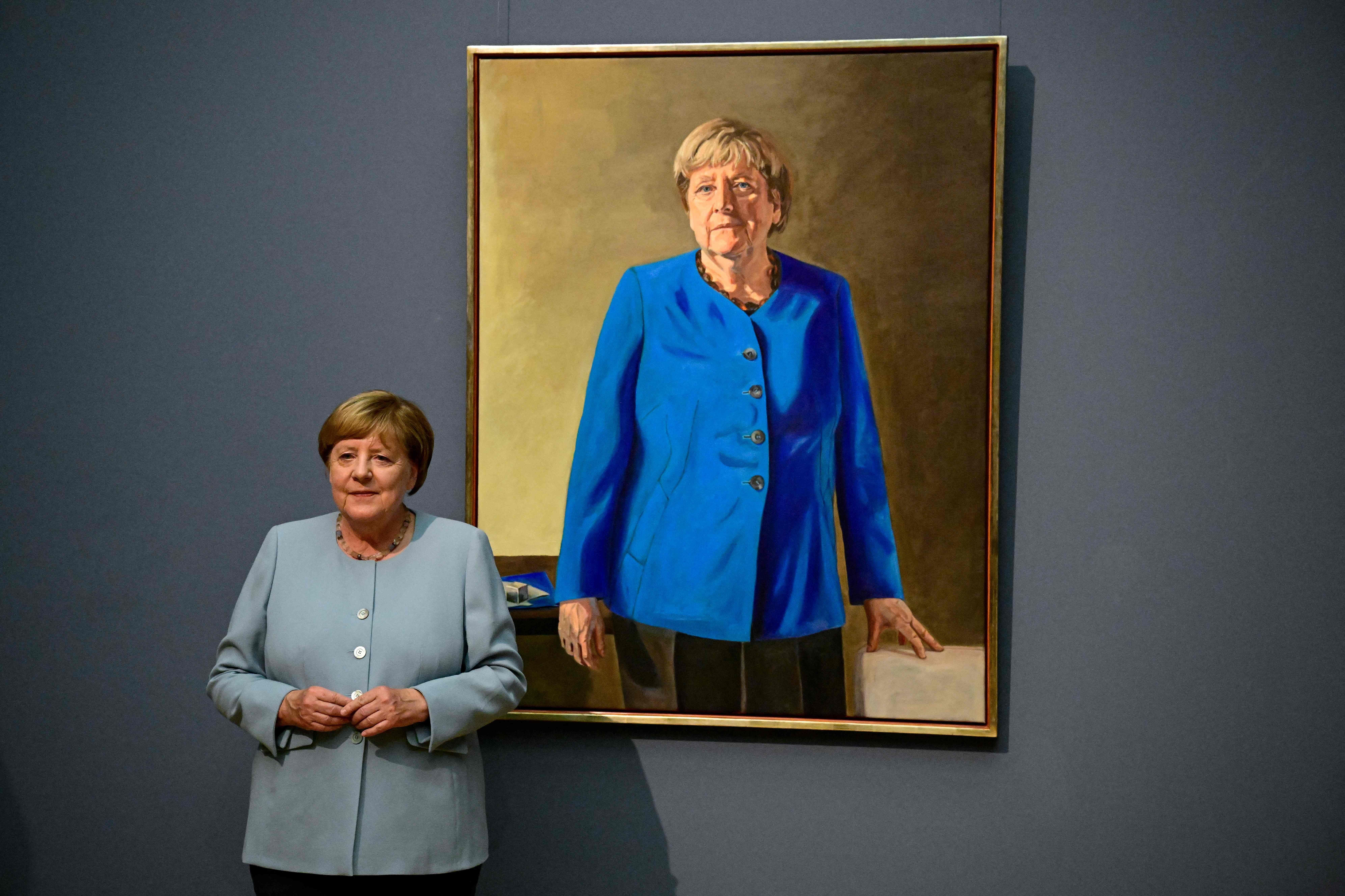 Angela Merkel steht neben einem Gemälde von ihr im Bode Museum in Berlin.